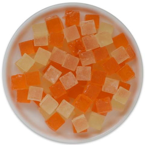 A vibrant tray of Candy Cubes - Mimosa featuring orange and sparkling wine flavors, adorned with edible glitter for a festive look.