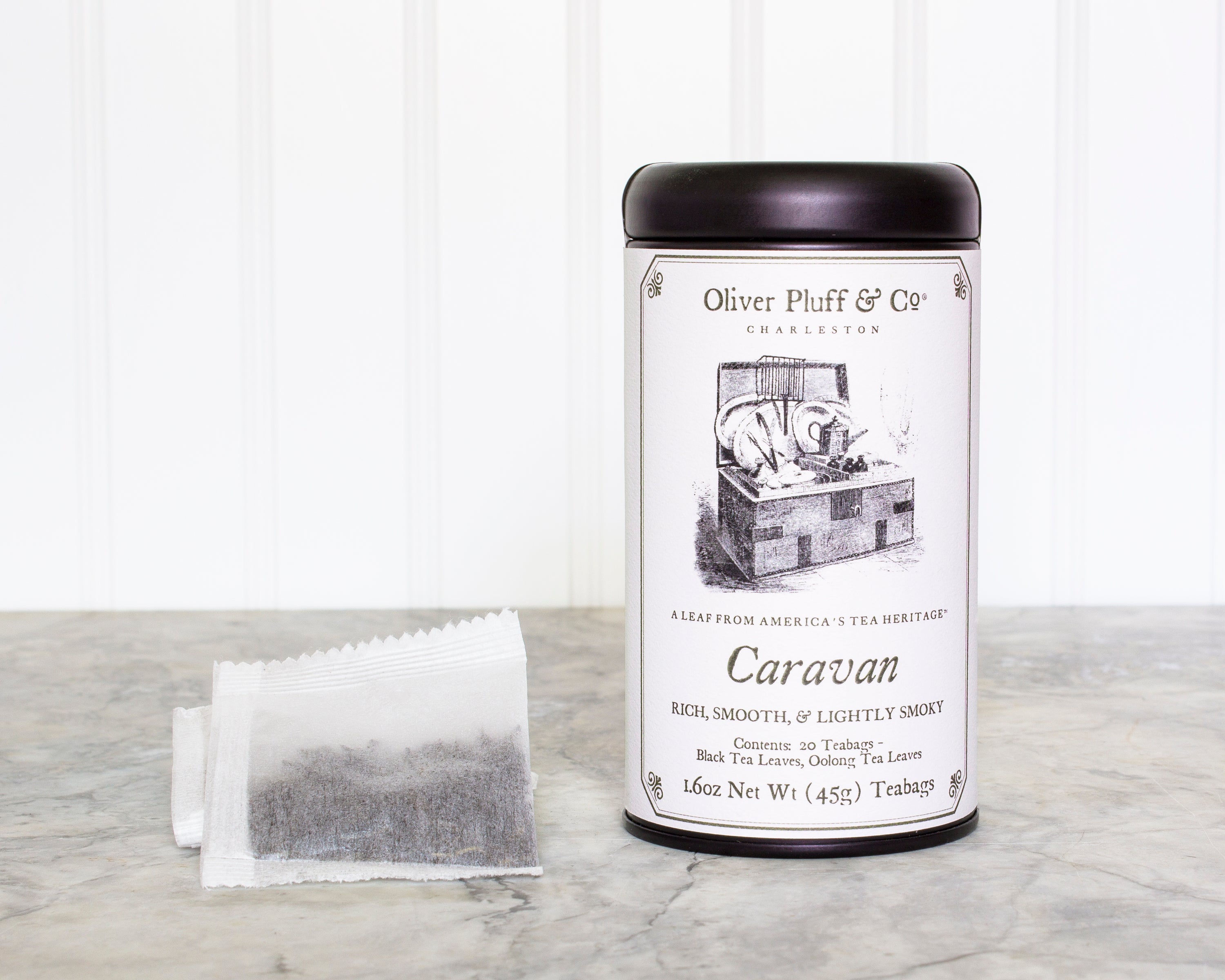 Caravan Teabags in a matte black signature tin, showcasing 20 pyramid-style teabags with a rich, smoky black tea blend.