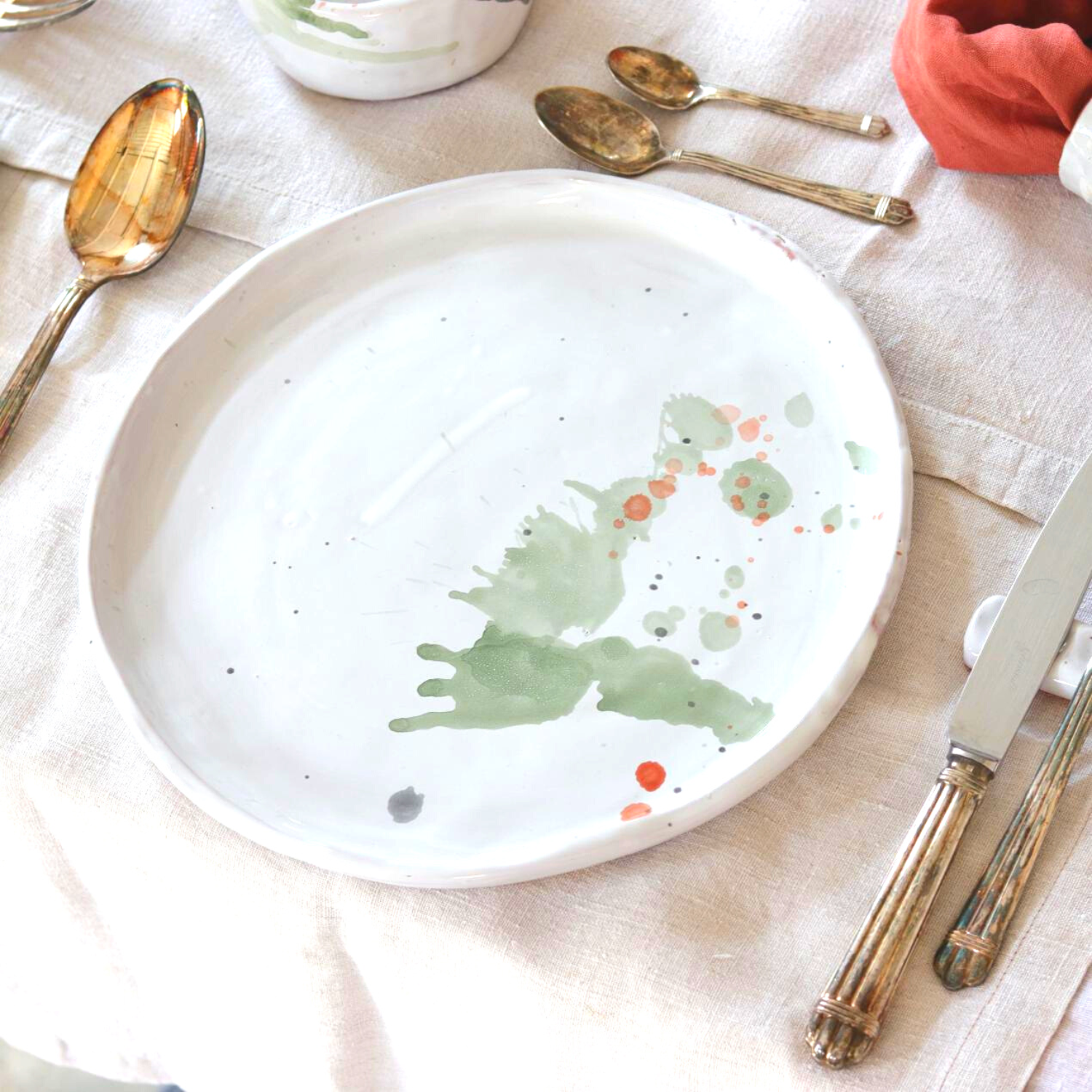 Ceramic Handmade Dinnerplate featuring a unique watercolour design in shades of green, grey, blue, and subtle orange, showcasing artisanal craftsmanship.