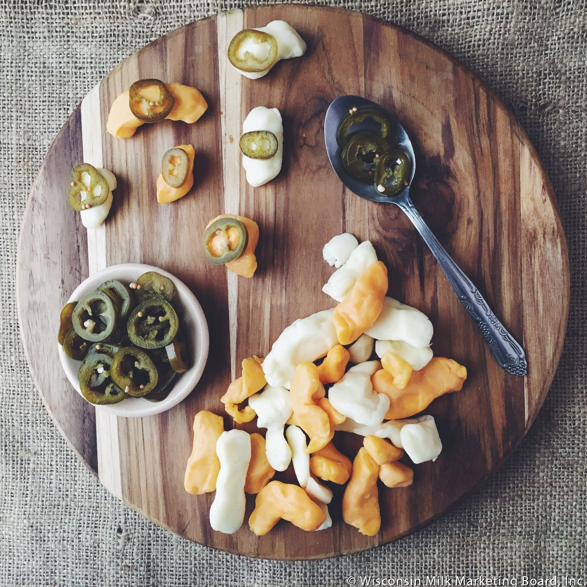 A close-up of fresh white cheese curds, showcasing their irregular shapes and creamy texture, perfect for snacking or cooking.