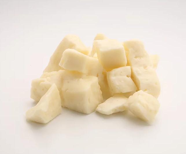 A close-up of fresh white cheese curds, showcasing their irregular shapes and creamy texture, perfect for snacking or cooking.