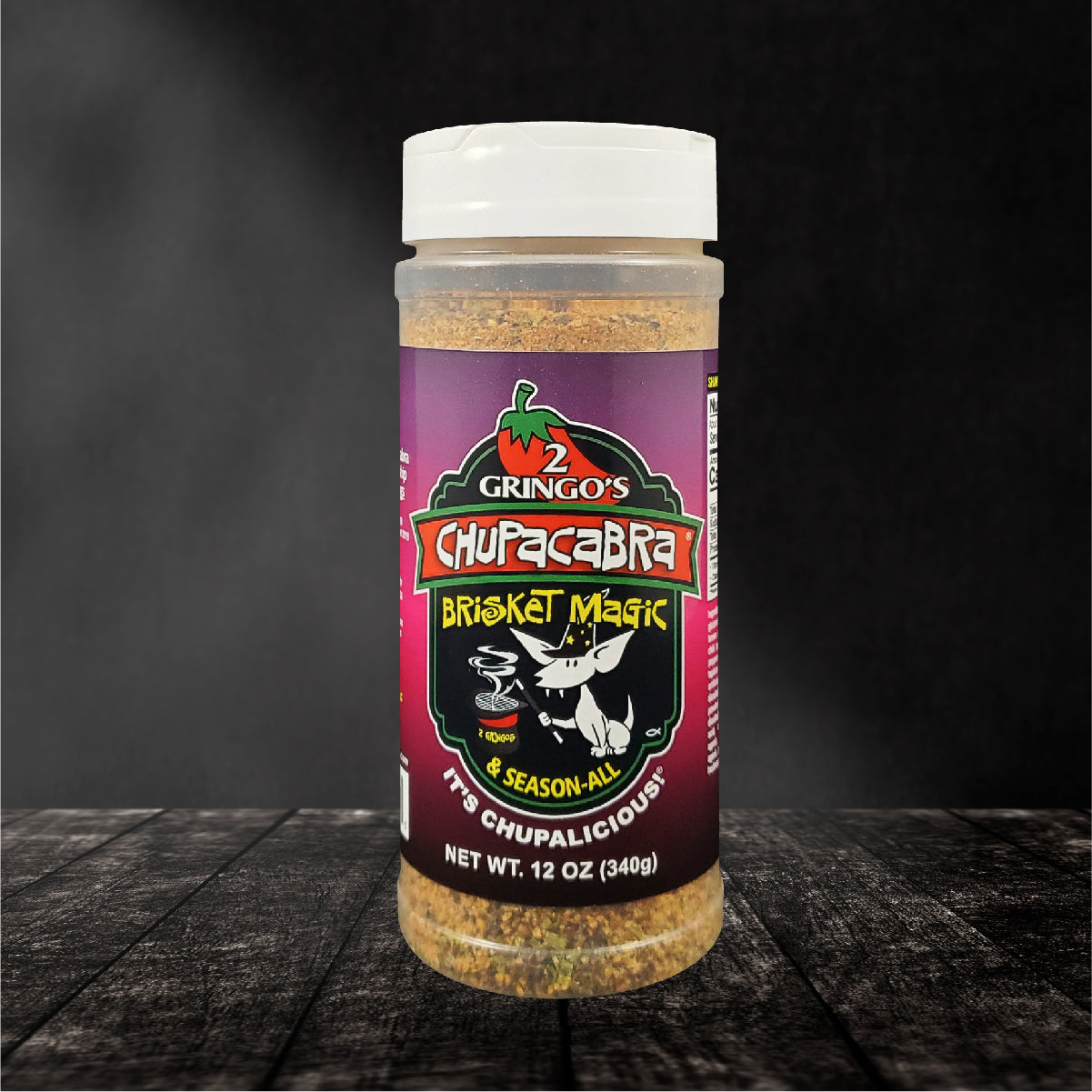 Chupacabra Brisket Magic 12 Oz spice blend in a clear container, showcasing its rich, colorful herbs and spices.