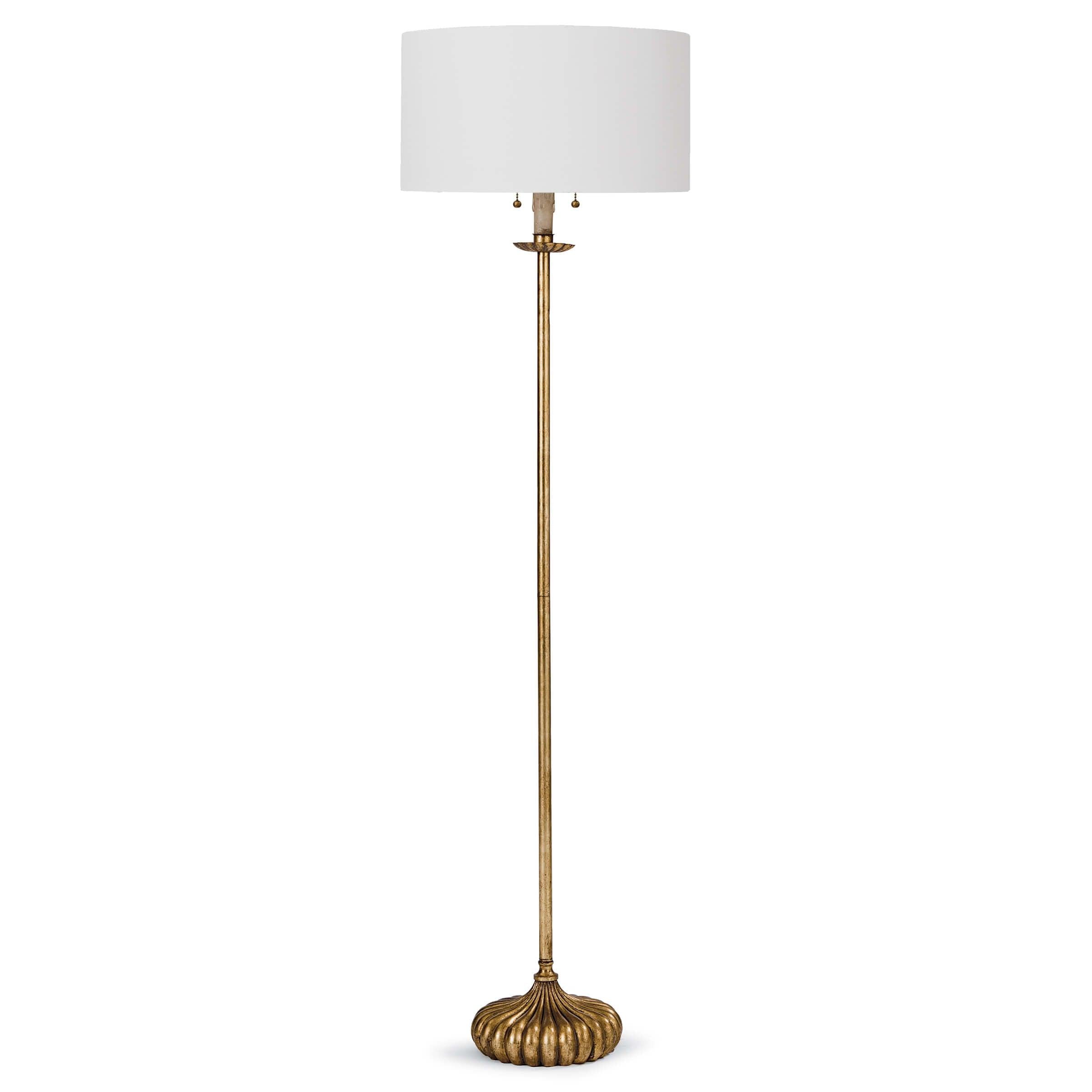 Clove Stem Floor Lamp with antiqued gold base and white linen shade, standing elegantly in a stylish room.