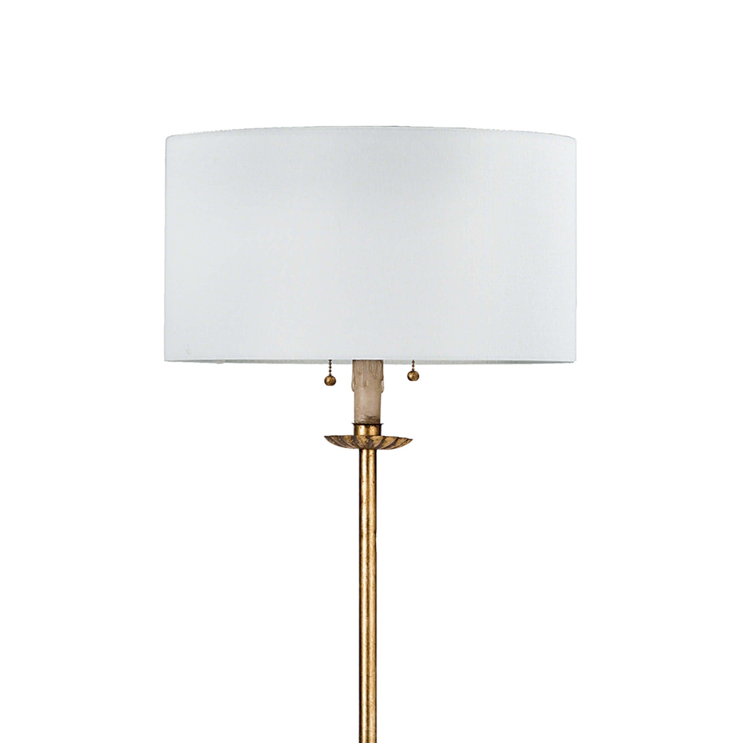 Clove Stem Floor Lamp with antiqued gold base and white linen shade, standing elegantly in a stylish room.