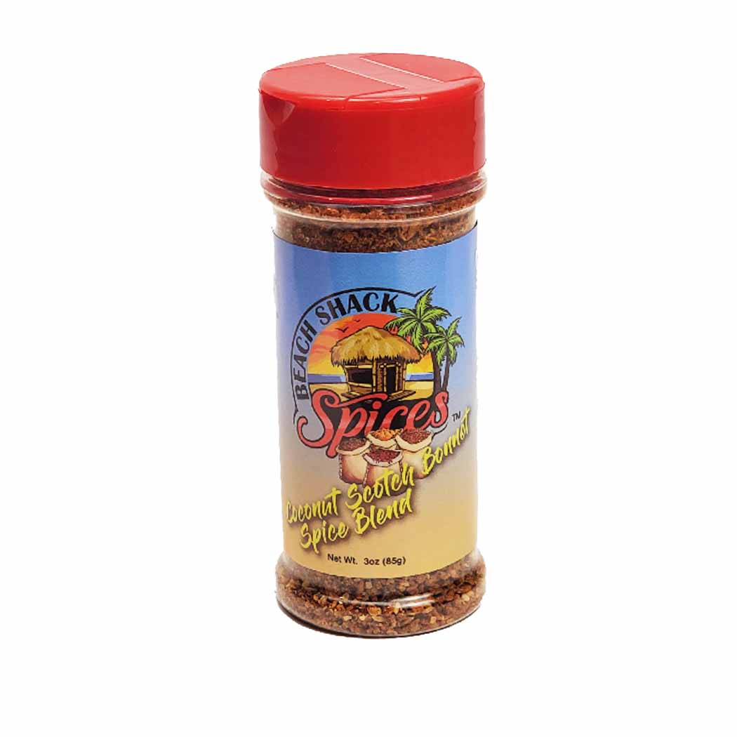 Coconut Scotch Bonnet Spice Blend in a glass jar with a wooden spoon, showcasing its vibrant colors and texture.