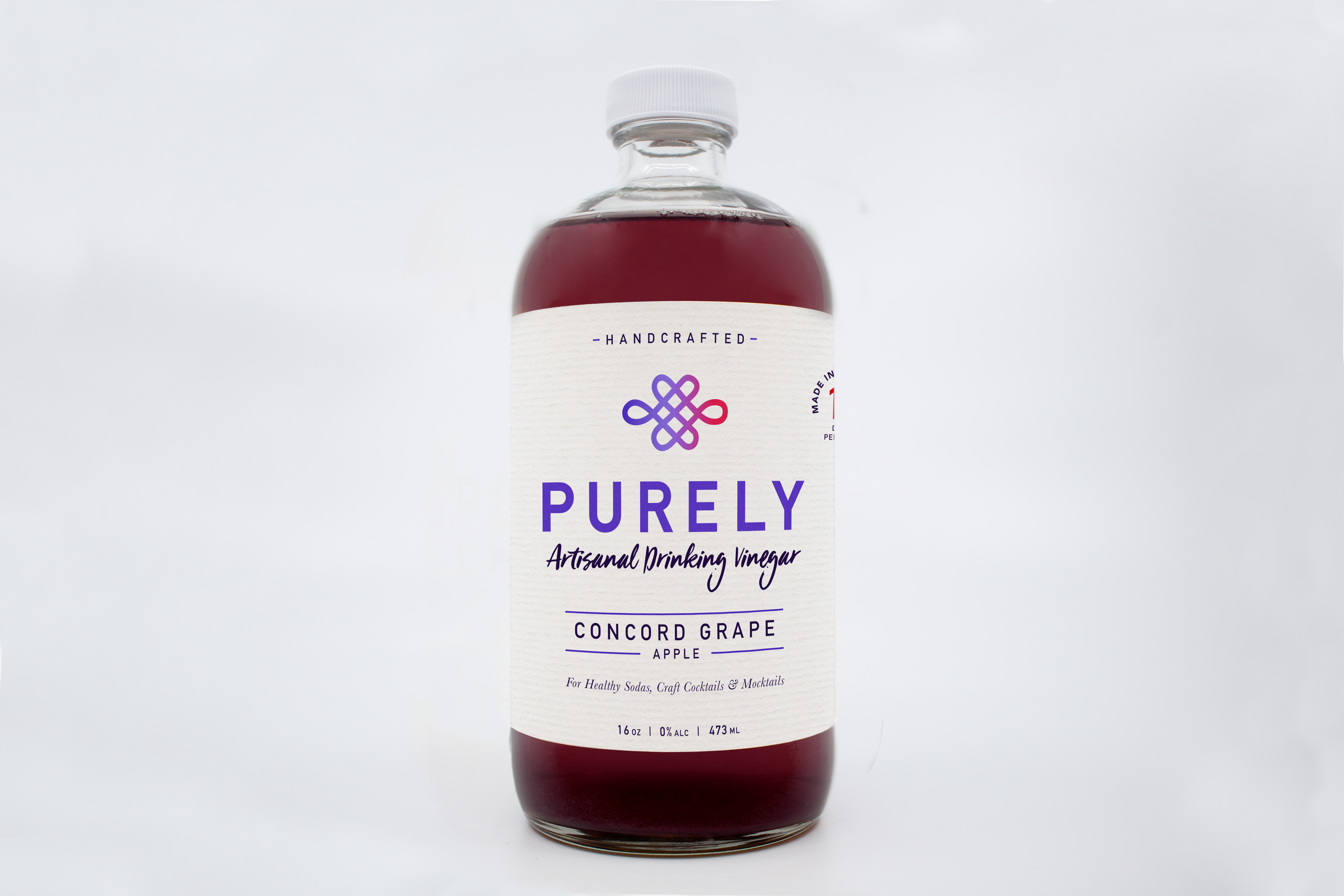 A 16oz bottle of Concord Grape Apple Infusion showcasing vibrant grape and apple colors, emphasizing its organic ingredients.