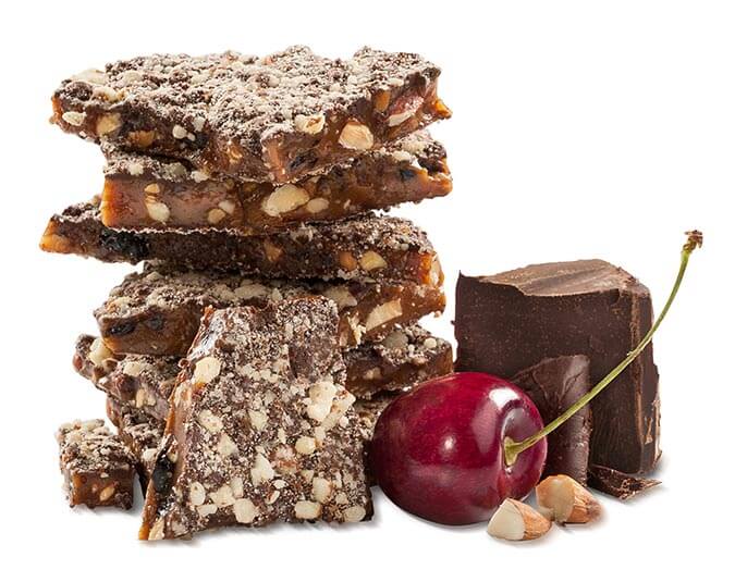 A close-up of Dark Chocolate Cherry Toffee pieces, showcasing the rich dark chocolate coating and visible dried cherries, elegantly arranged on a rustic wooden surface.