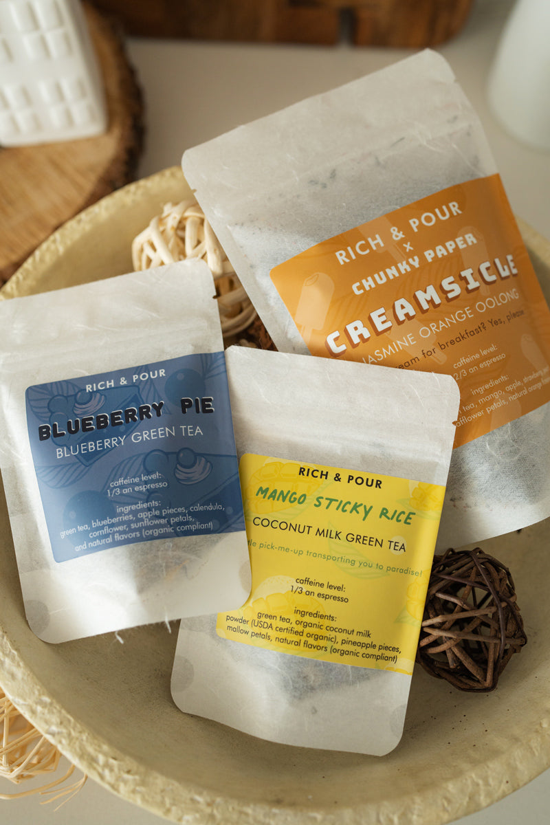 A beautifully arranged Dessert Lovers Set featuring three unique tea blends: Blueberry Pie, Mango Sticky Rice, and Creamsicle, all in elegant packaging.