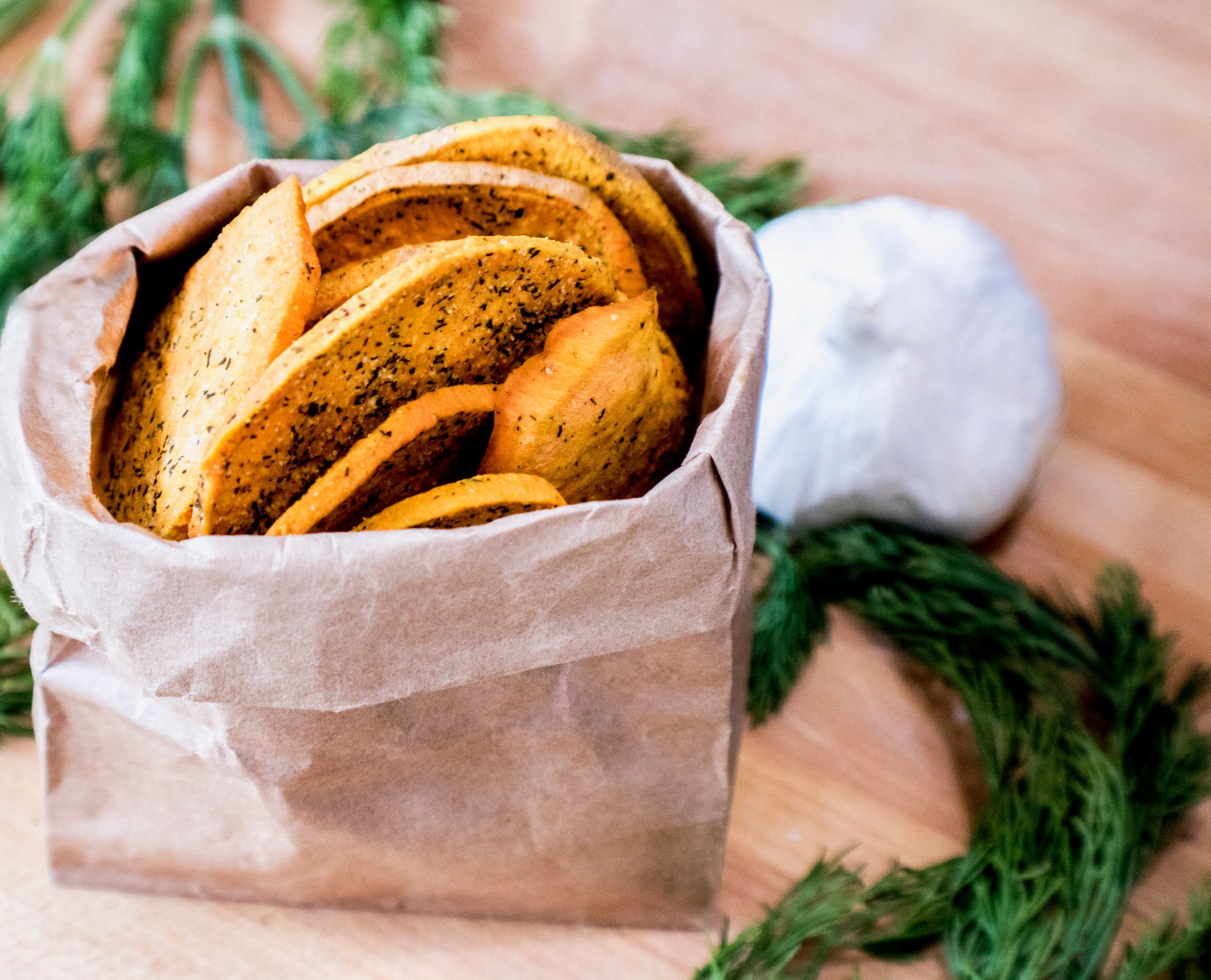 A close-up of Dill and Garlic slices, showcasing their crispy texture and seasoning of dill and garlic granules.