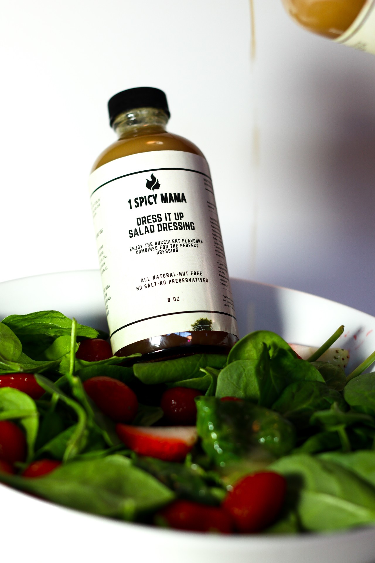 A 10 oz bottle of Dress It Up Salad Dressing featuring a blend of garlic, lemon, and spices, ideal for salads and more.