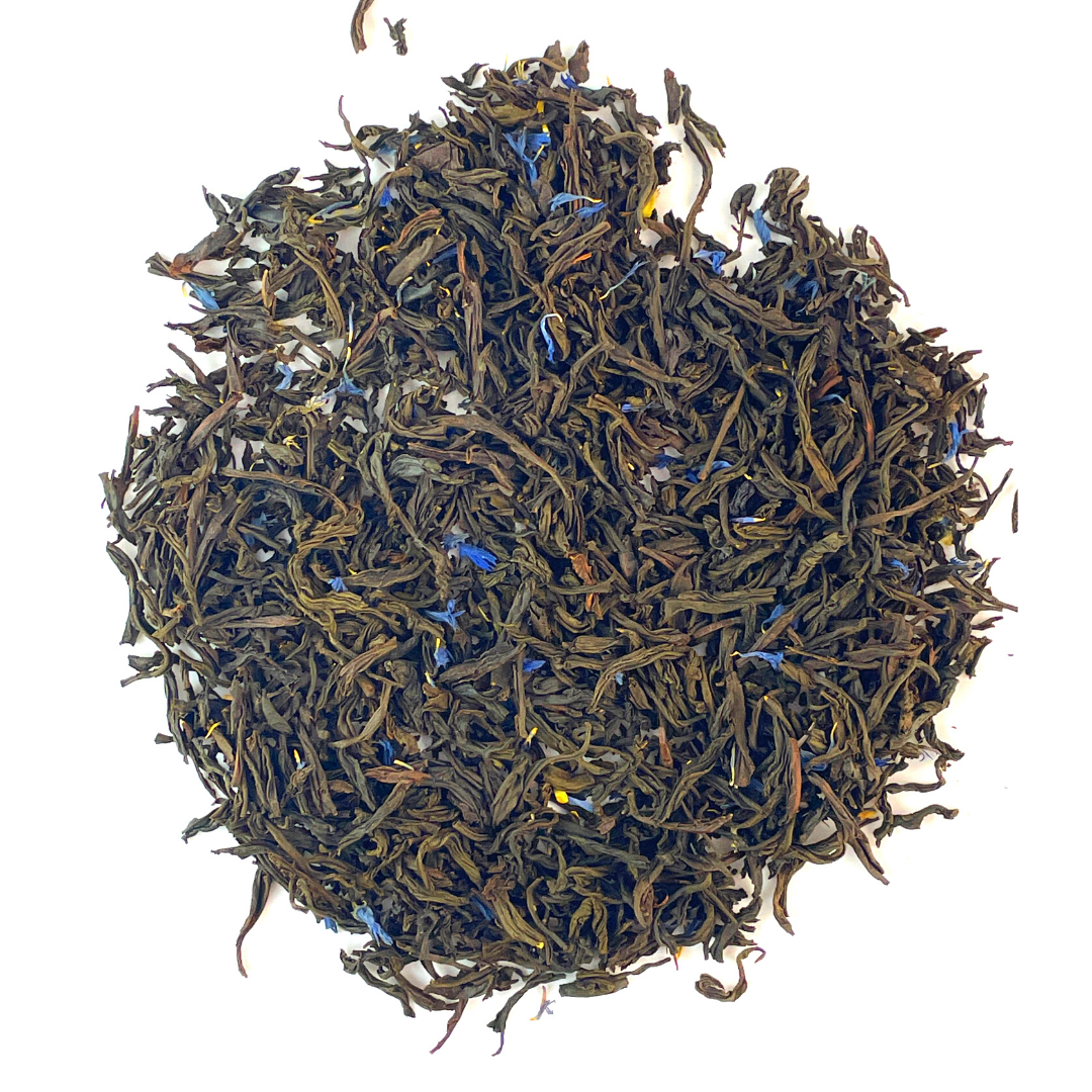 A cup of Earl Grey Tea with loose leaf tea and bergamot, showcasing its rich color and aroma.