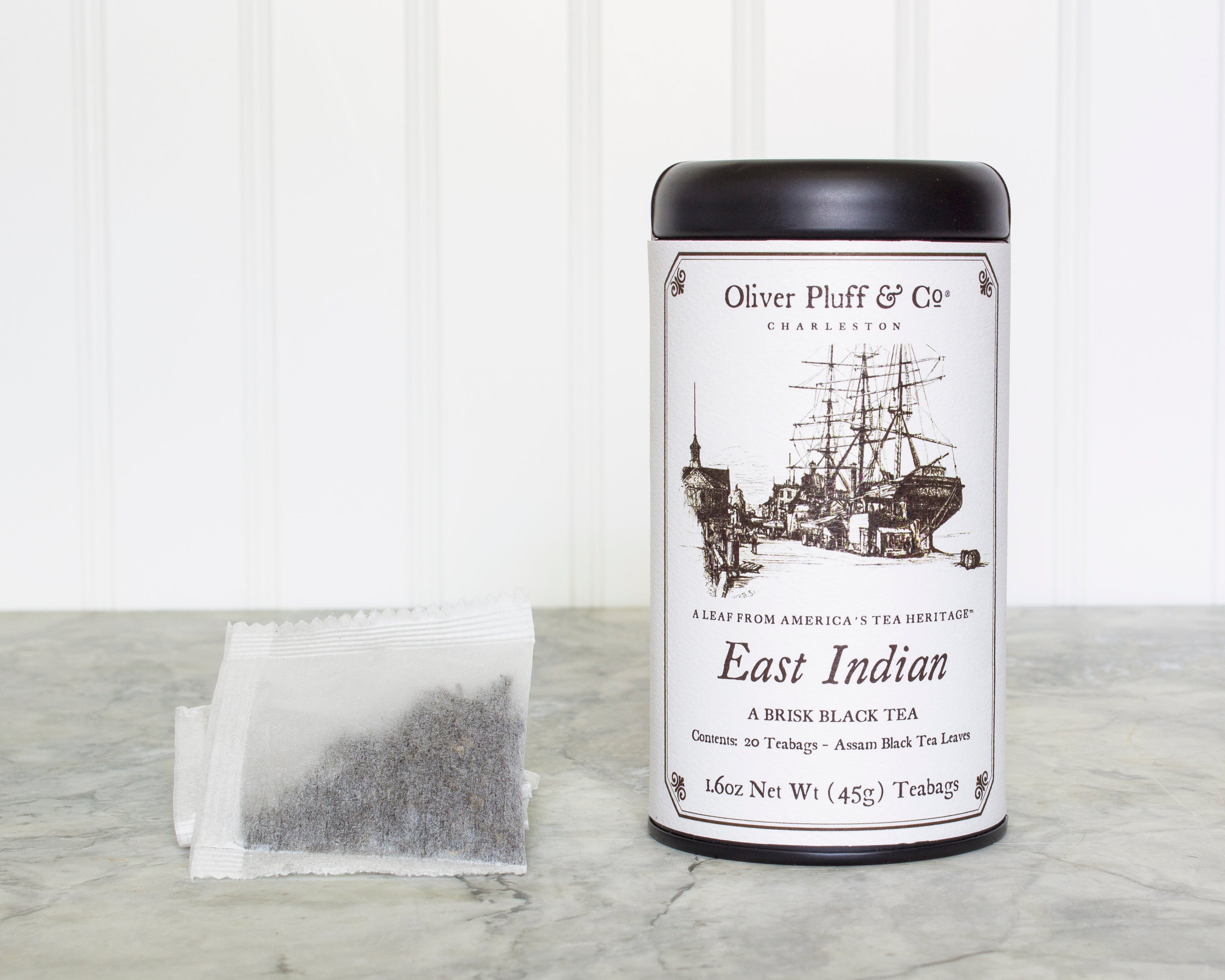 A matte black signature tea tin containing 20 East Indian teabags, showcasing elegant packaging and premium quality.