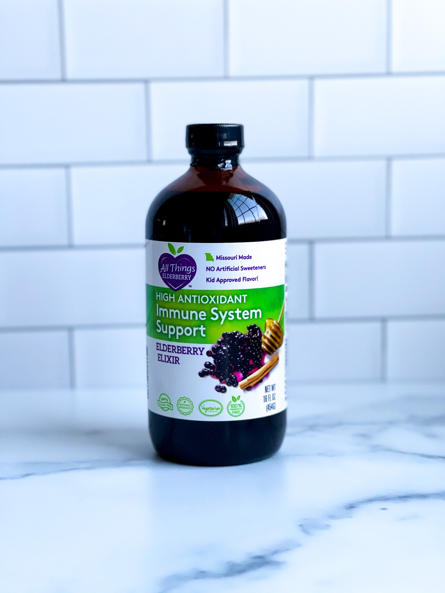 A bottle of Elderberry Elixir made with fresh elderberries, showcasing its rich purple color and organic ingredients.