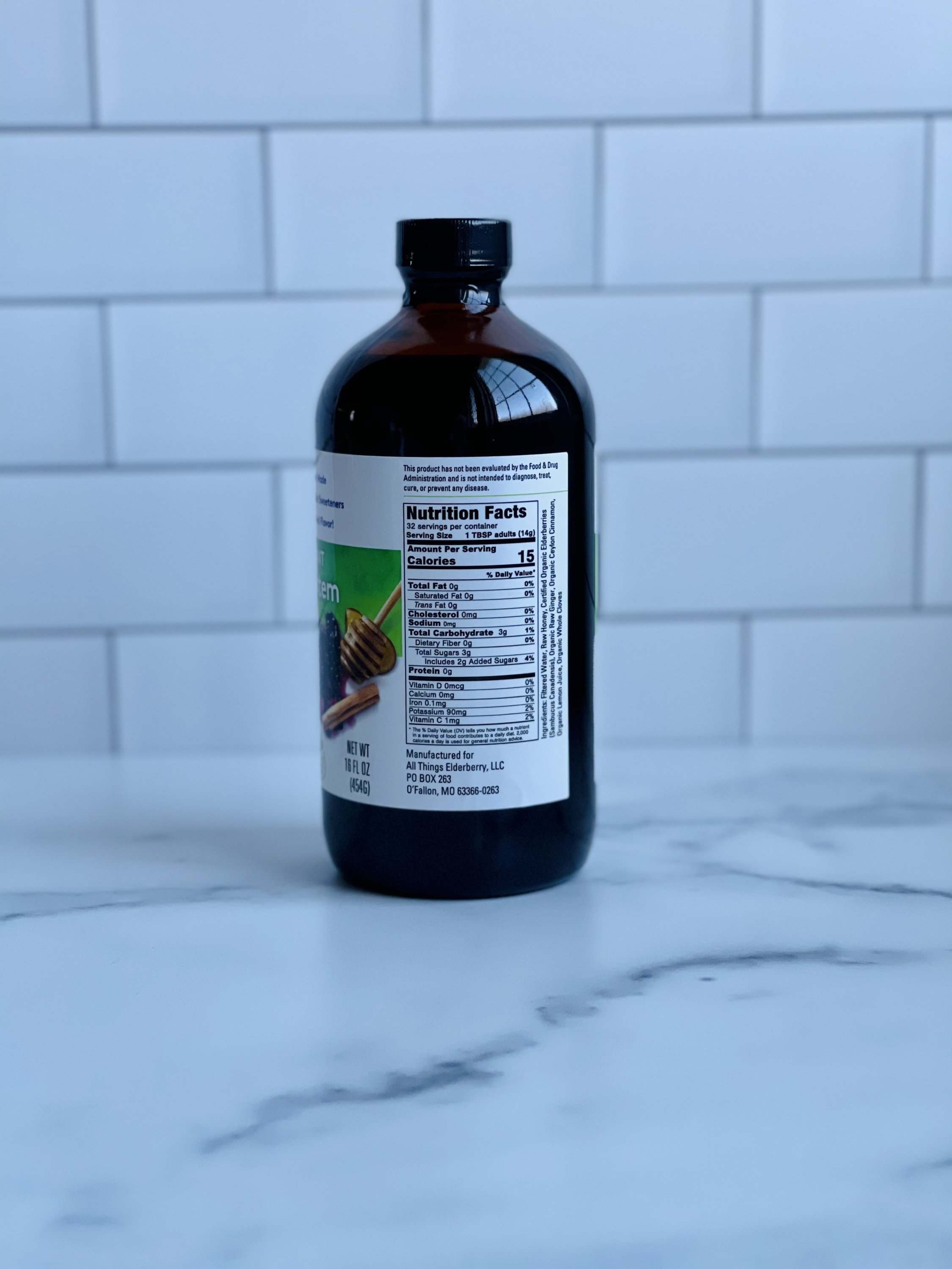 A bottle of Elderberry Elixir made with fresh elderberries, showcasing its rich purple color and organic ingredients.