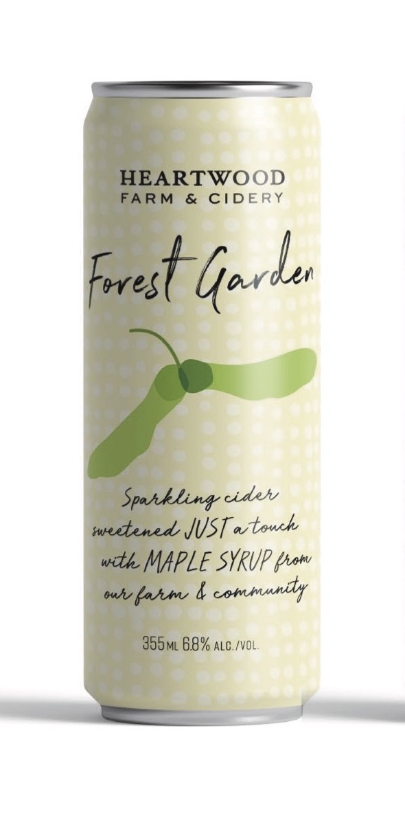 A bottle of Forest Garden sparkling cider surrounded by fresh apples and maple leaves, showcasing its natural ingredients and vibrant colors.