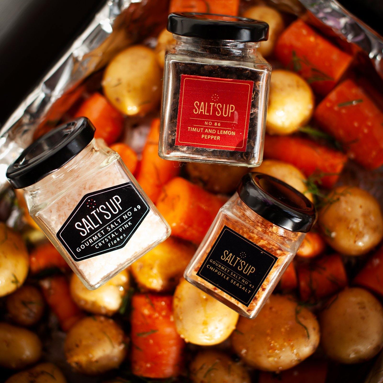 A beautifully arranged gift box containing five gourmet salts, a salt plate, and a tealight holder made of salt, perfect for culinary enthusiasts.