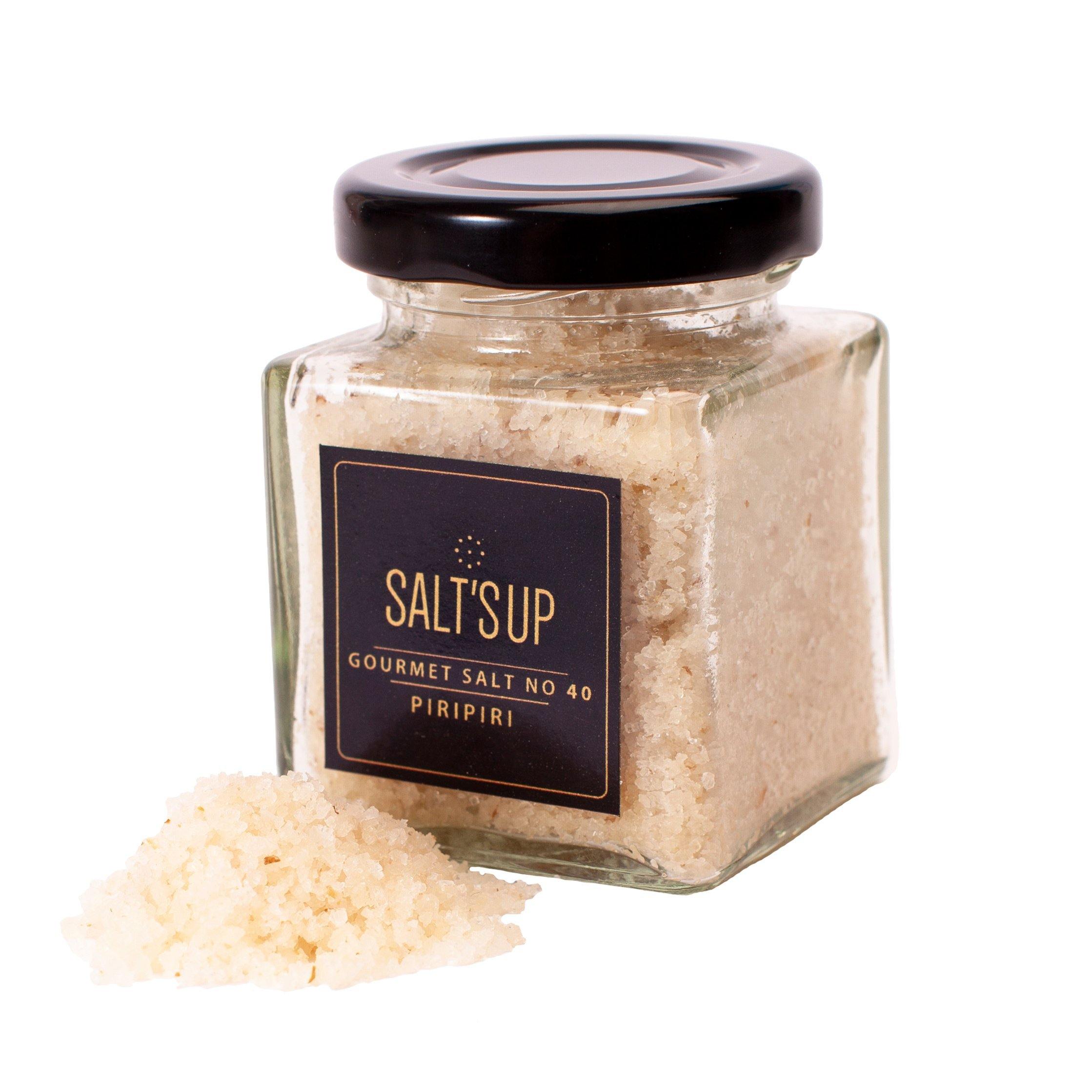 A beautifully arranged gift box containing five gourmet salts, a salt plate, and a tealight holder made of salt, perfect for culinary enthusiasts.