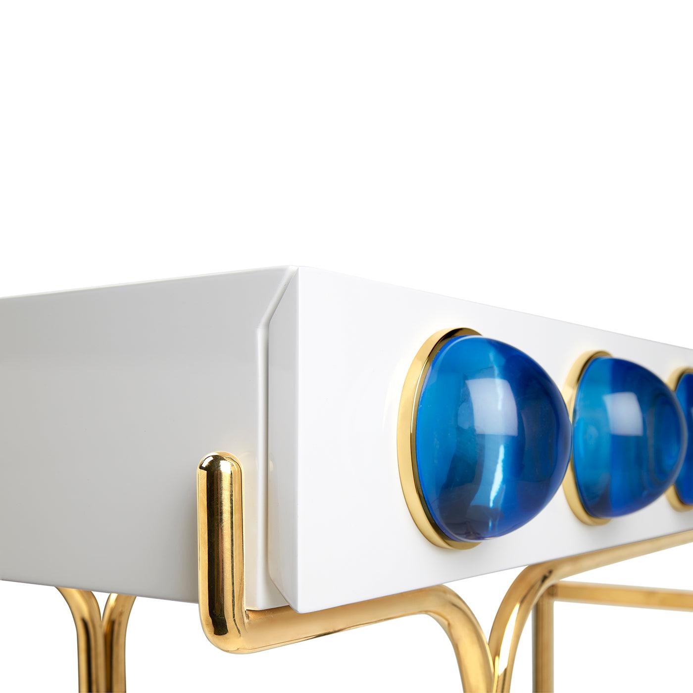 Globo Console featuring glossy white lacquer, brass framework, and blue acrylic cabochons.