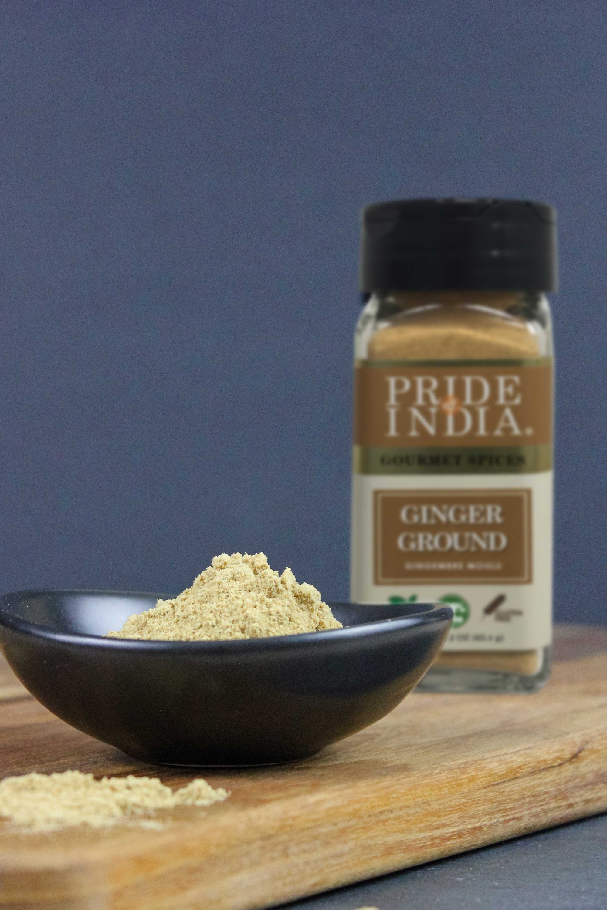 A jar of Pride of India Gourmet Ginger Fine Ground showcasing its fine texture and rich yellow color, perfect for enhancing dishes.