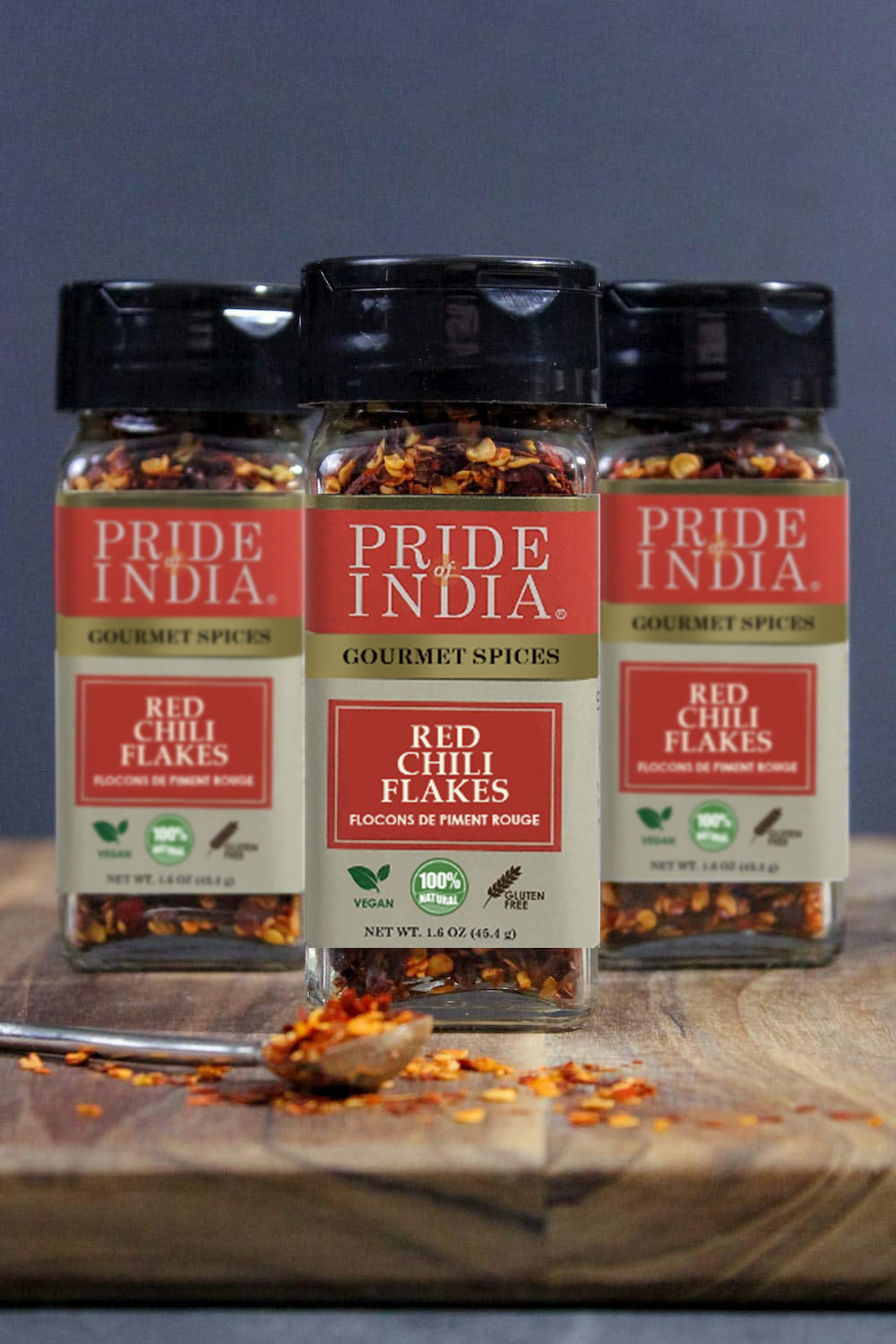 A jar of Pride Of India Gourmet Red Chili Flakes Hot, showcasing vibrant red crushed chili peppers, ideal for adding spice to dishes.