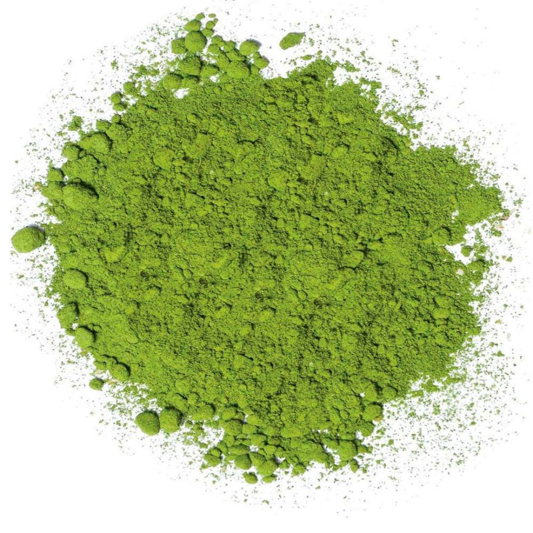 A vibrant green bowl of Kikos Green Matcha Tea powder with a whisk, showcasing its rich color and texture.