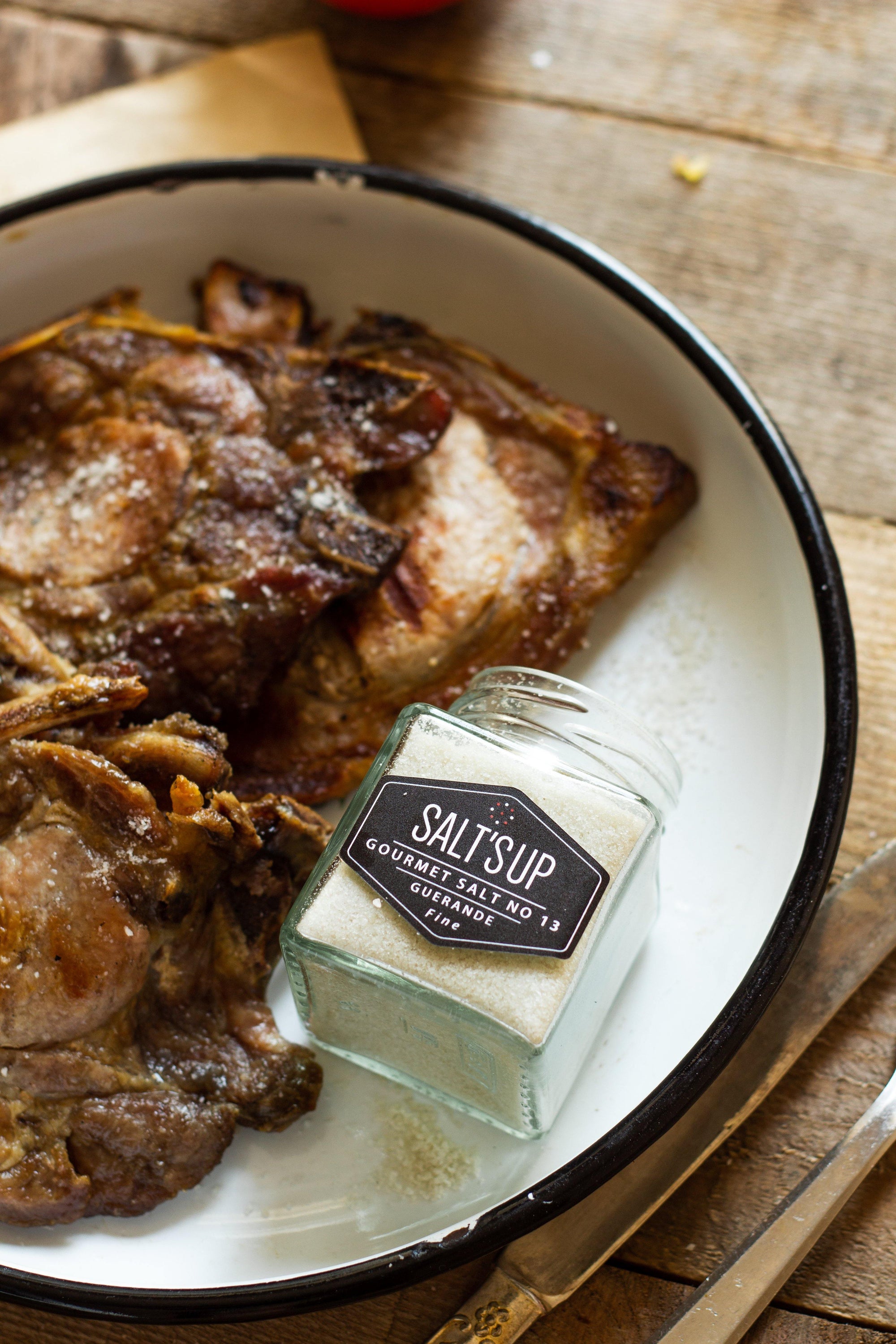 A jar of GUERANDE fine salt showcasing its grey color and artisanal packaging, ideal for enhancing flavors in cooking.