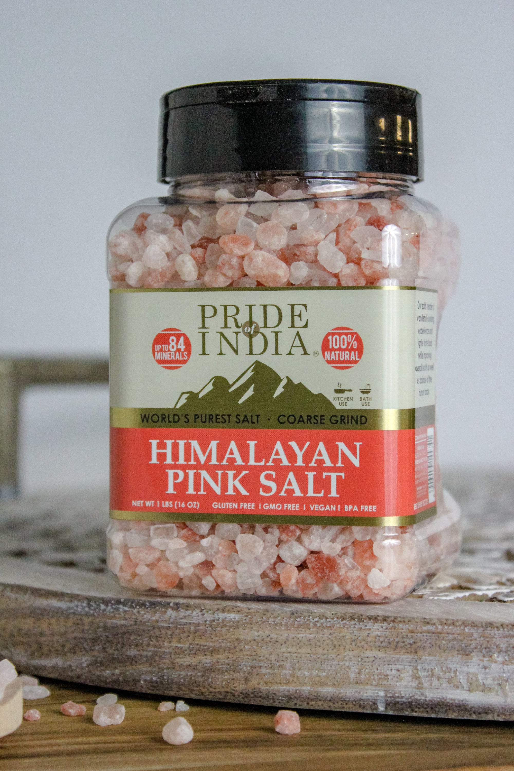 Coarse grind Himalayan pink rock salt in a wooden bowl, showcasing its natural reddish-pink color and texture.