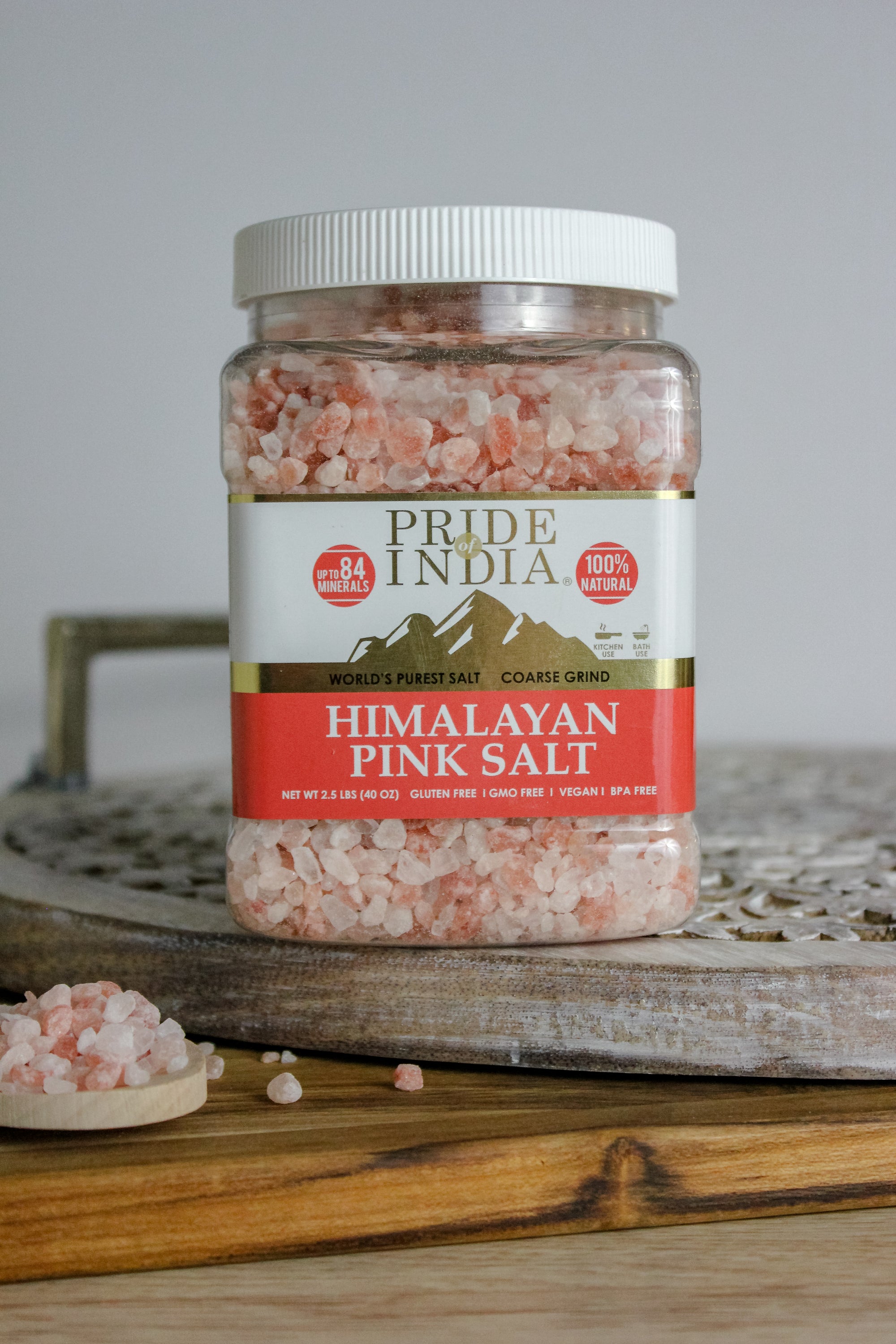 Coarse grind Himalayan pink rock salt in a wooden bowl, showcasing its natural reddish-pink color and texture.