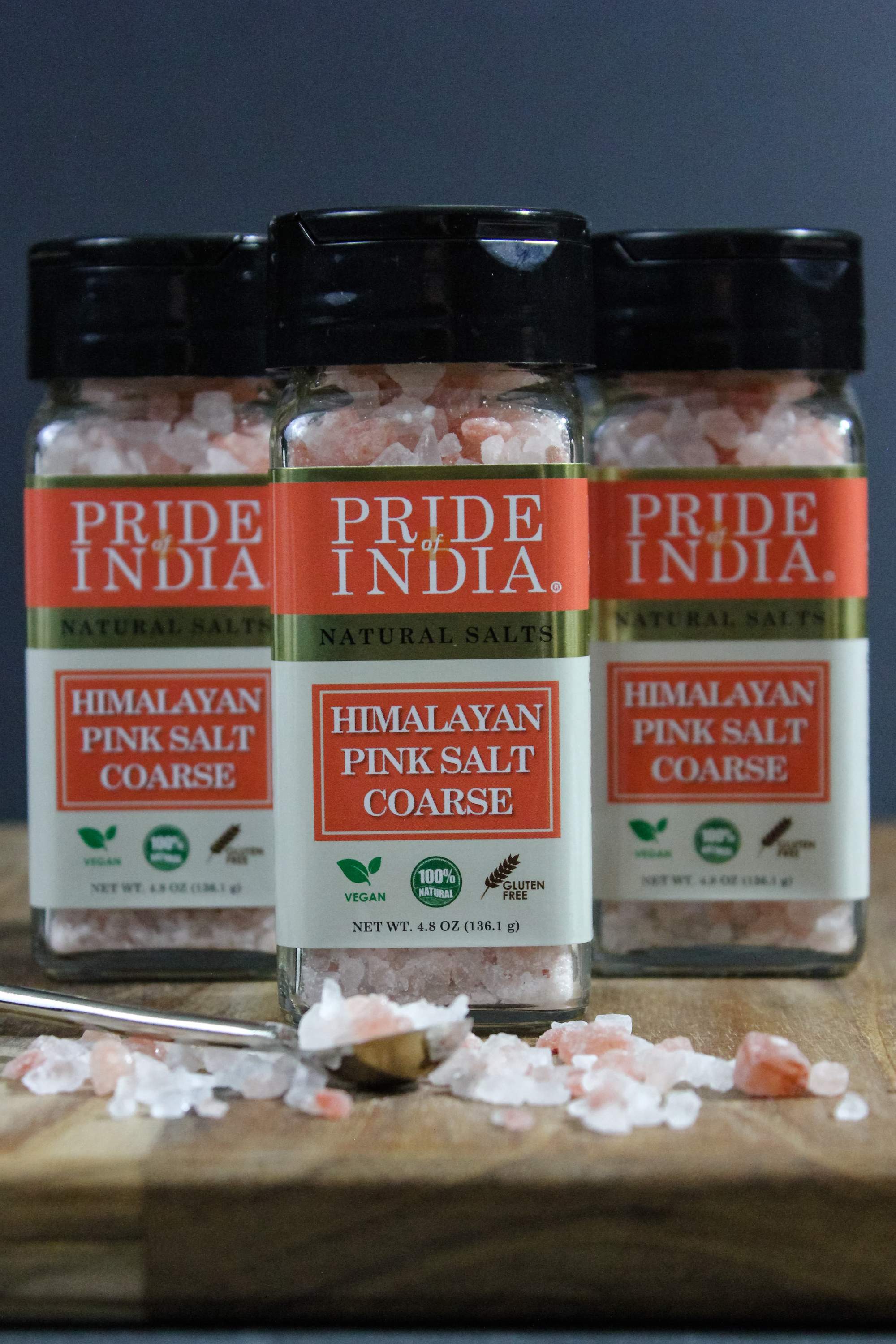 Coarse grind Himalayan pink rock salt in a wooden bowl, showcasing its natural reddish-pink color and texture.