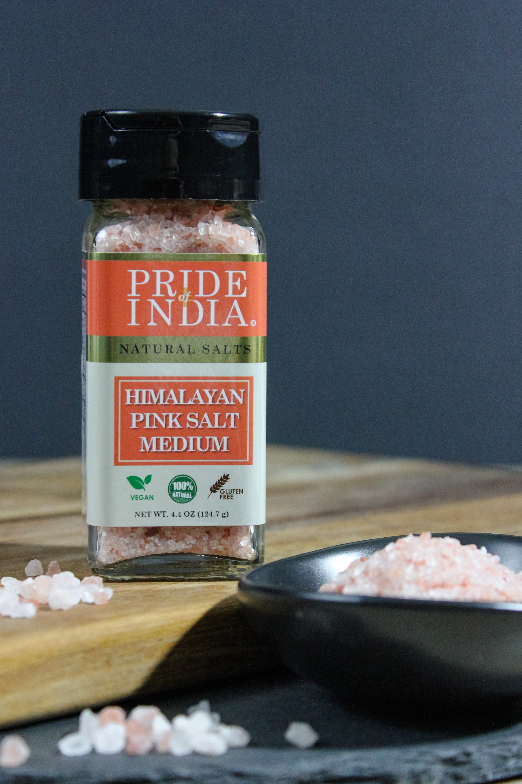 A bowl of Himalayan Pink Rock Salt - Medium Grind showcasing its coarse texture and reddish-pink color, ideal for cooking and therapeutic uses.