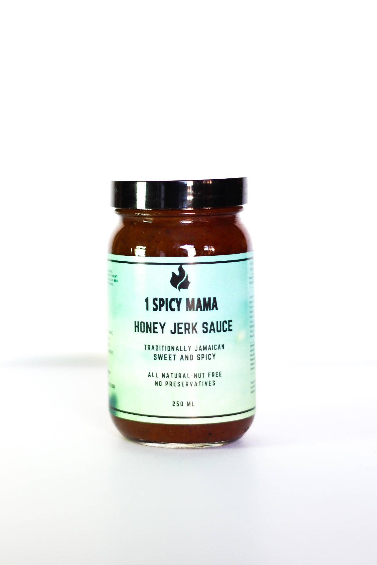 A bottle of Honey Jerk Sauce with a vibrant label, showcasing its rich, golden color and ingredients like peppers and honey in the background.