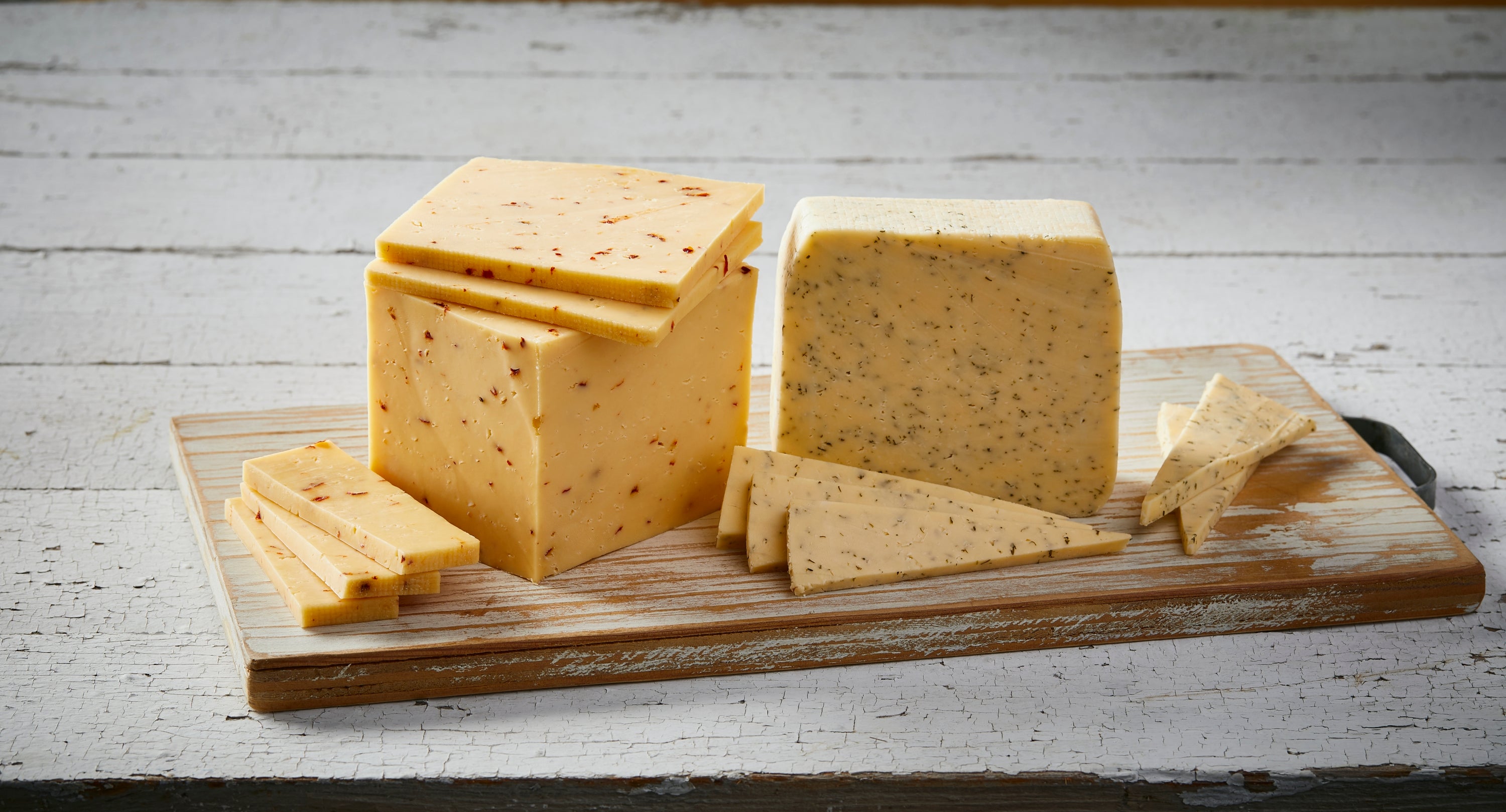 A wedge of Horseradish Havarti cheese infused with mustard seeds and chives, showcasing its creamy texture and unique flavor.