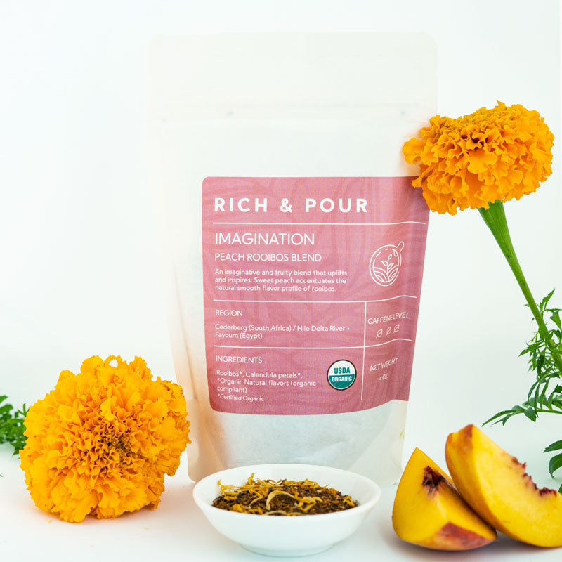 A vibrant package of Imagination Peach Rooibos Blend tea, showcasing its organic ingredients and fruity flavor profile.