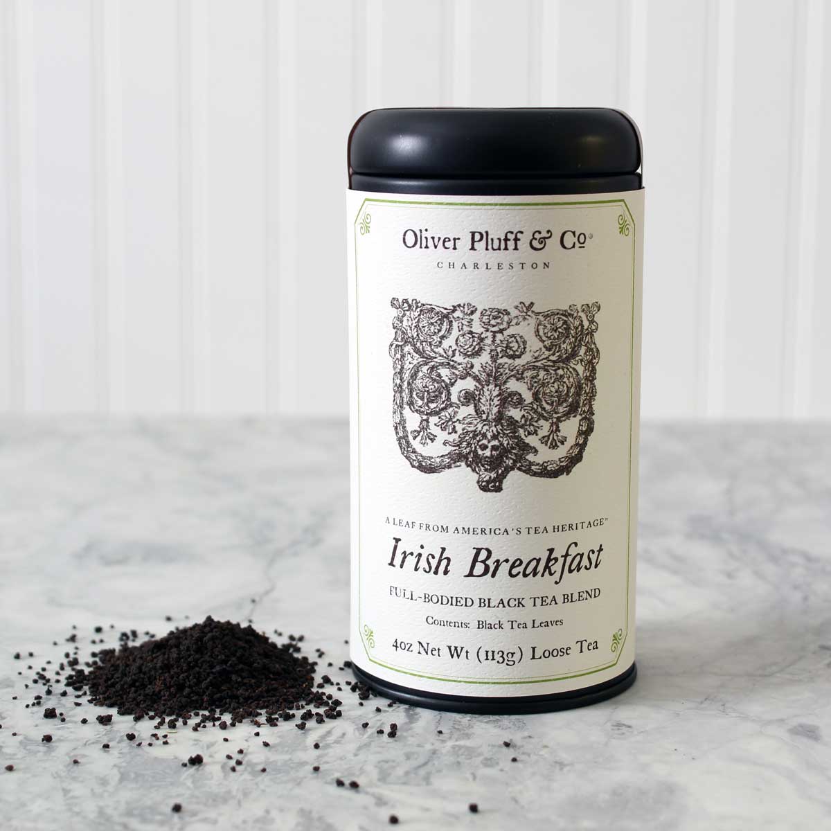 A matte black signature tea tin filled with Irish Breakfast Loose Tea, showcasing its rich and robust blend of Assam and Kenyan black teas.