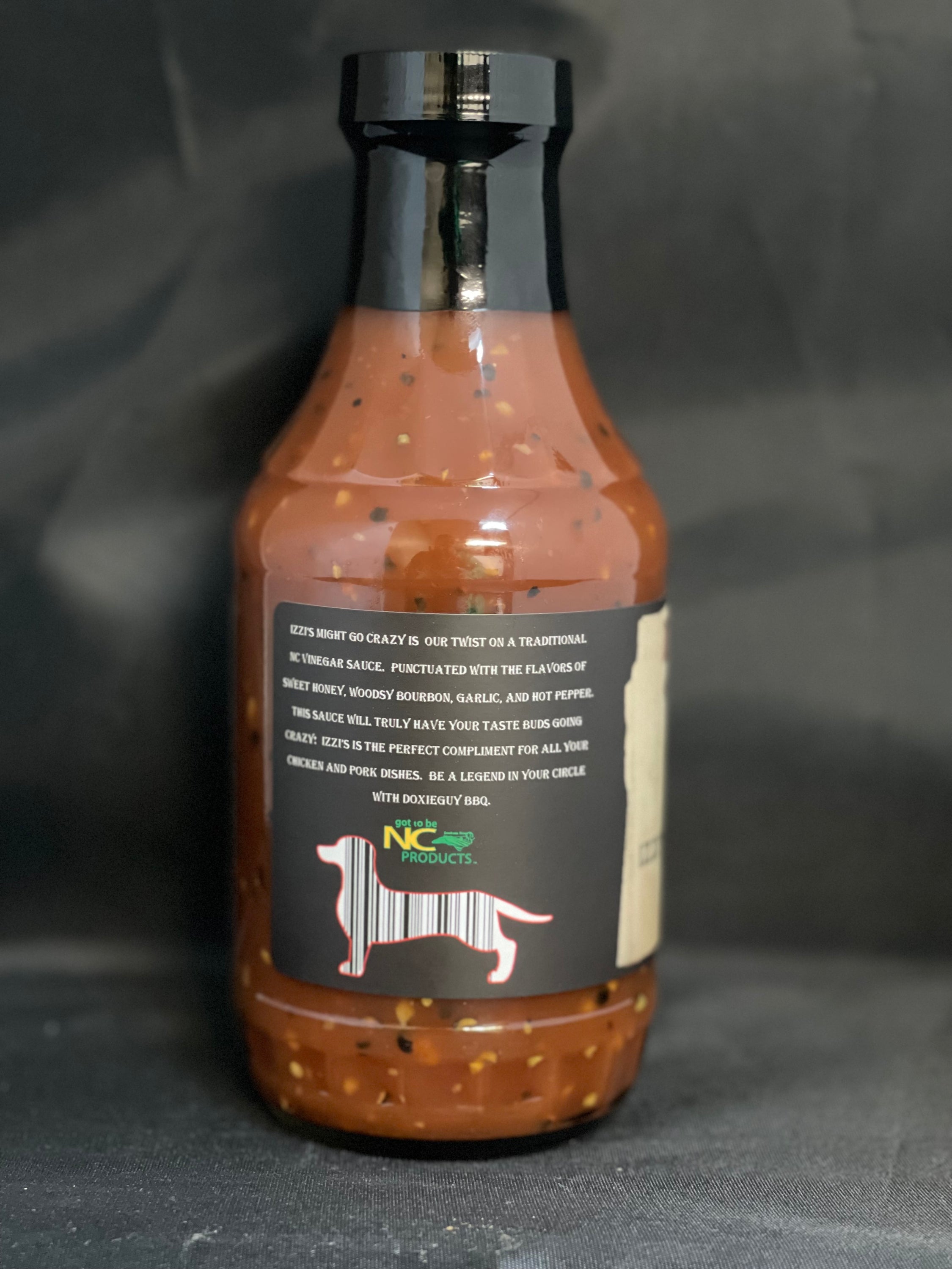 Bottle of Izzi's Might Go Crazy BBQ Sauce with a rich, dark color and a label featuring vibrant graphics, showcasing its unique flavor profile.