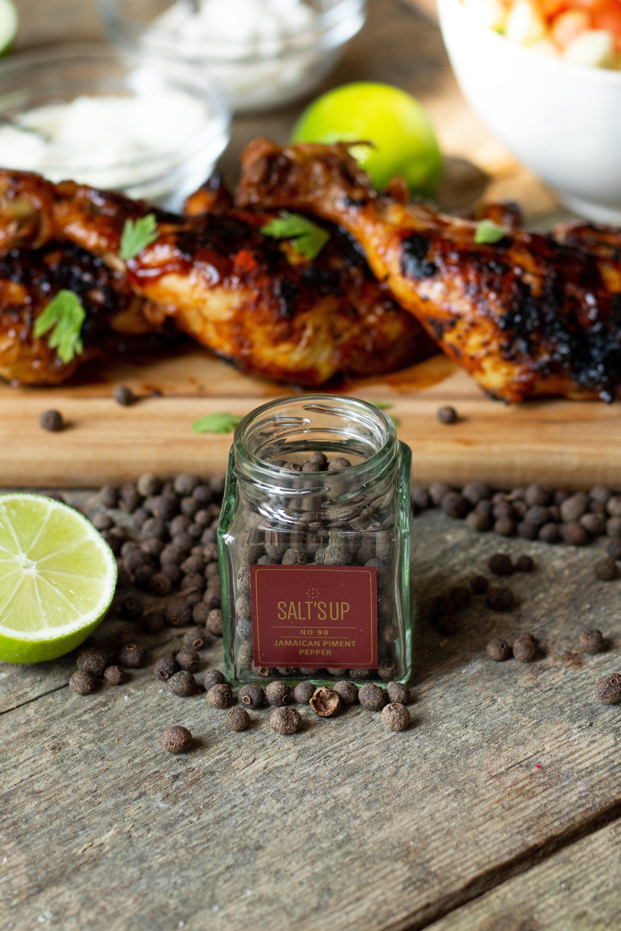 A glass jar containing 30g of Jamaican Piment pepper, showcasing its rich brown color and aromatic qualities.