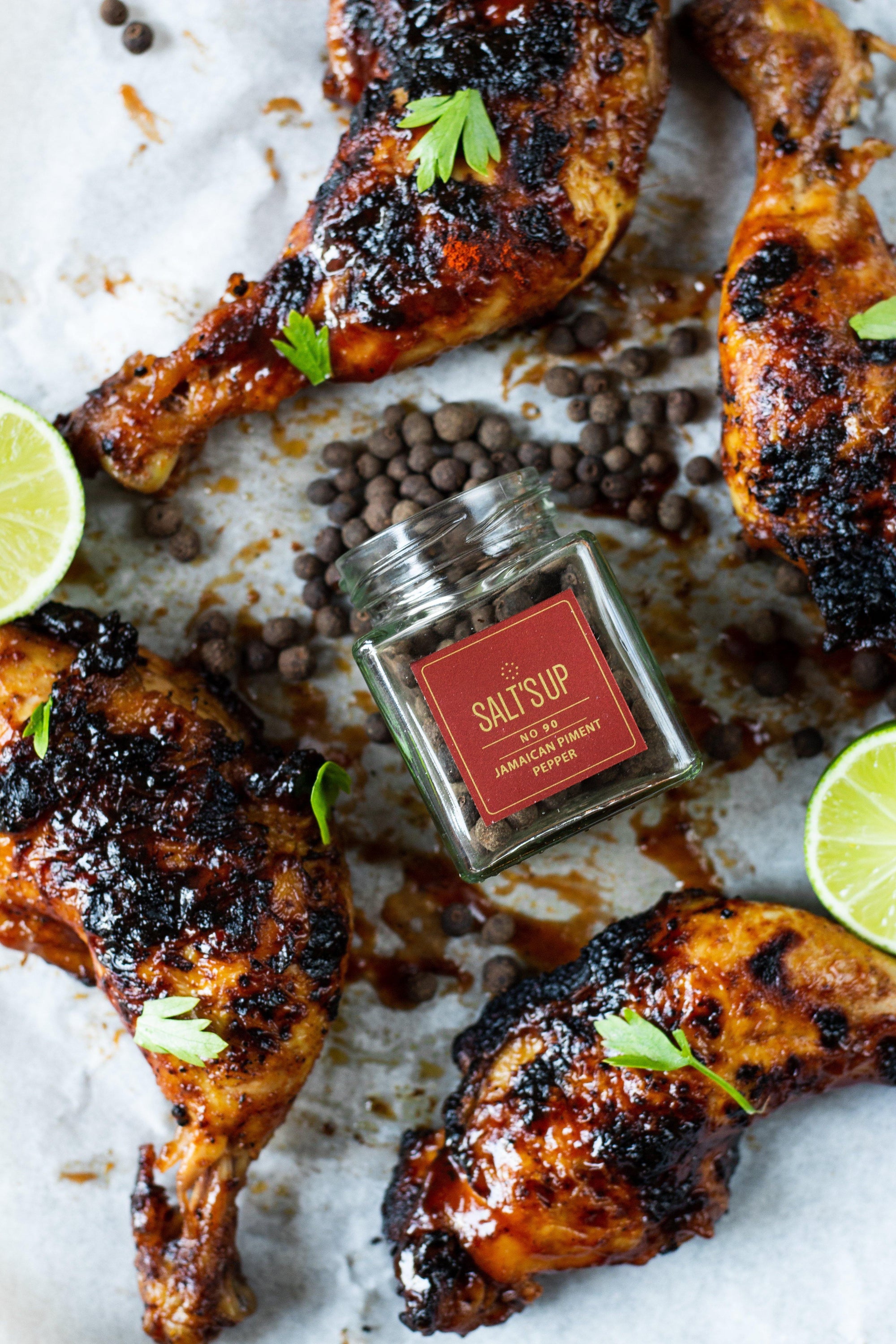 A glass jar containing 30g of Jamaican Piment pepper, showcasing its rich brown color and aromatic qualities.