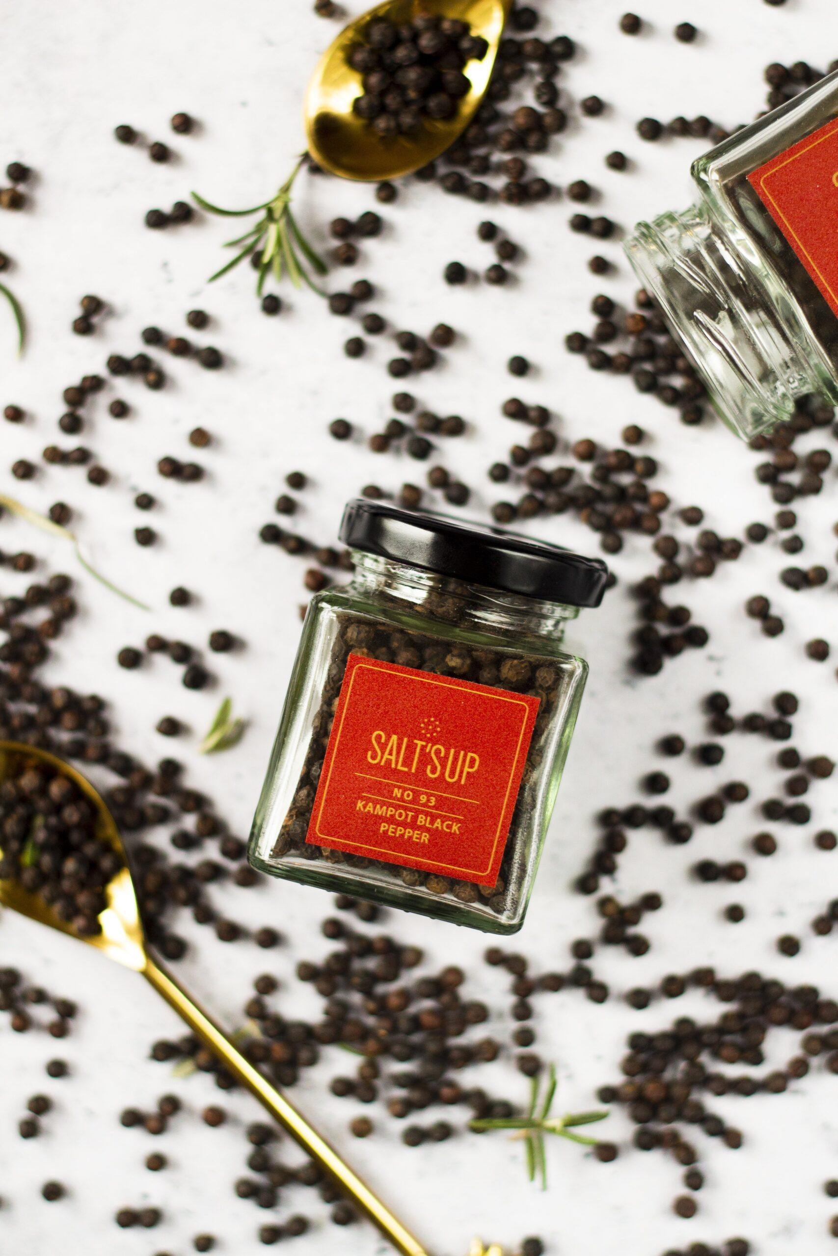 A close-up of KAMPOT BLACK pepper ecopack showcasing the rich black peppercorns and eco-friendly packaging.