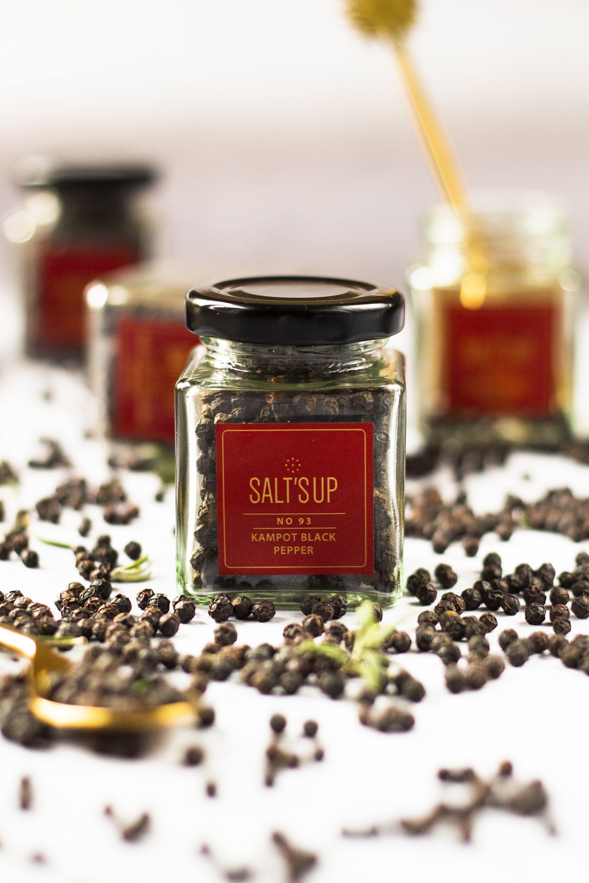 A glass jar of Kampot Black pepper showcasing its rich black color and aromatic qualities, perfect for gourmet cooking.