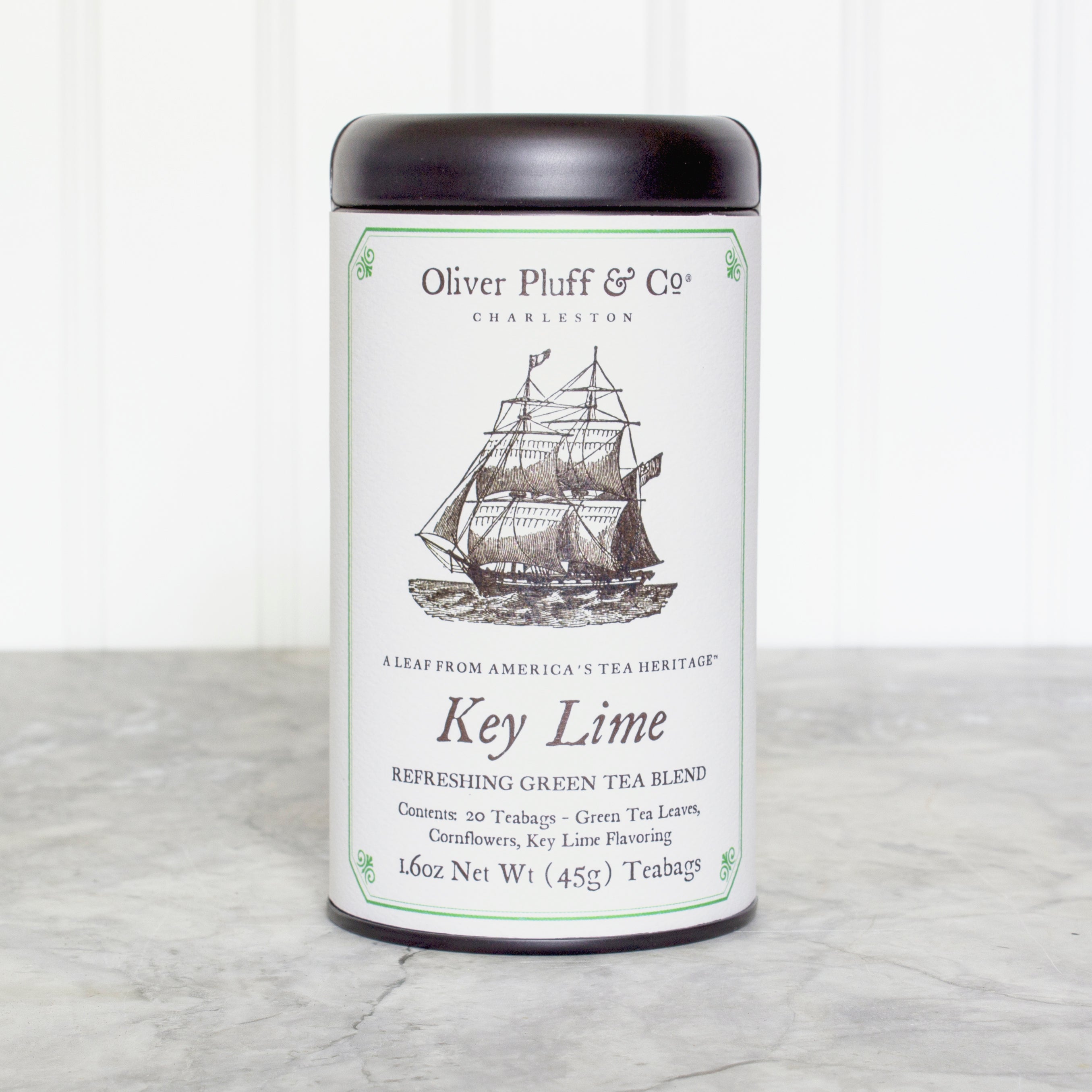 Key Lime Teabags in a matte black signature tea tin, showcasing the elegant packaging and vibrant tea sachets inside.