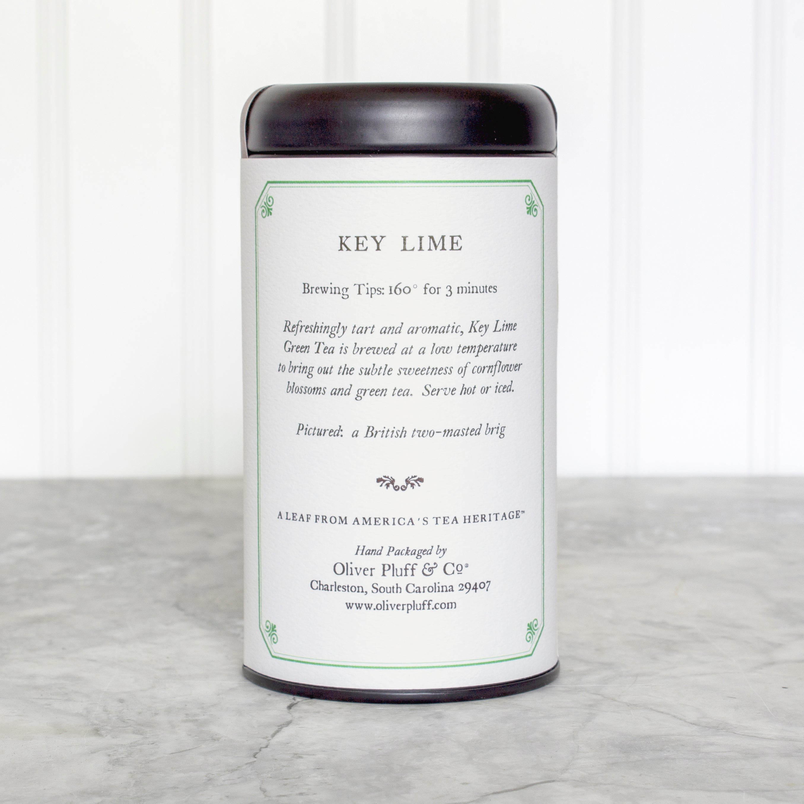 Key Lime Teabags in a matte black signature tea tin, showcasing the elegant packaging and vibrant tea sachets inside.