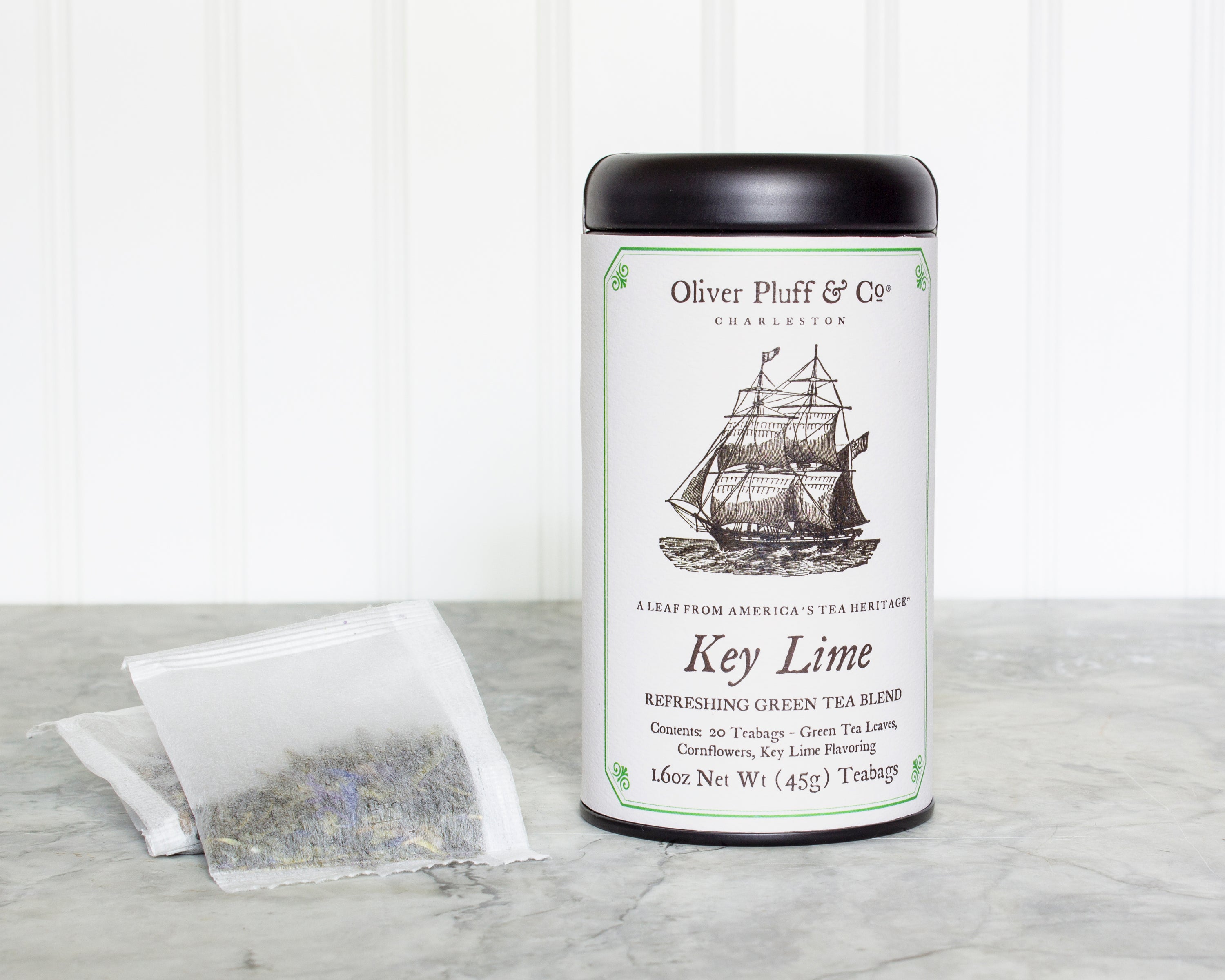 Key Lime Teabags in a matte black signature tea tin, showcasing the elegant packaging and vibrant tea sachets inside.