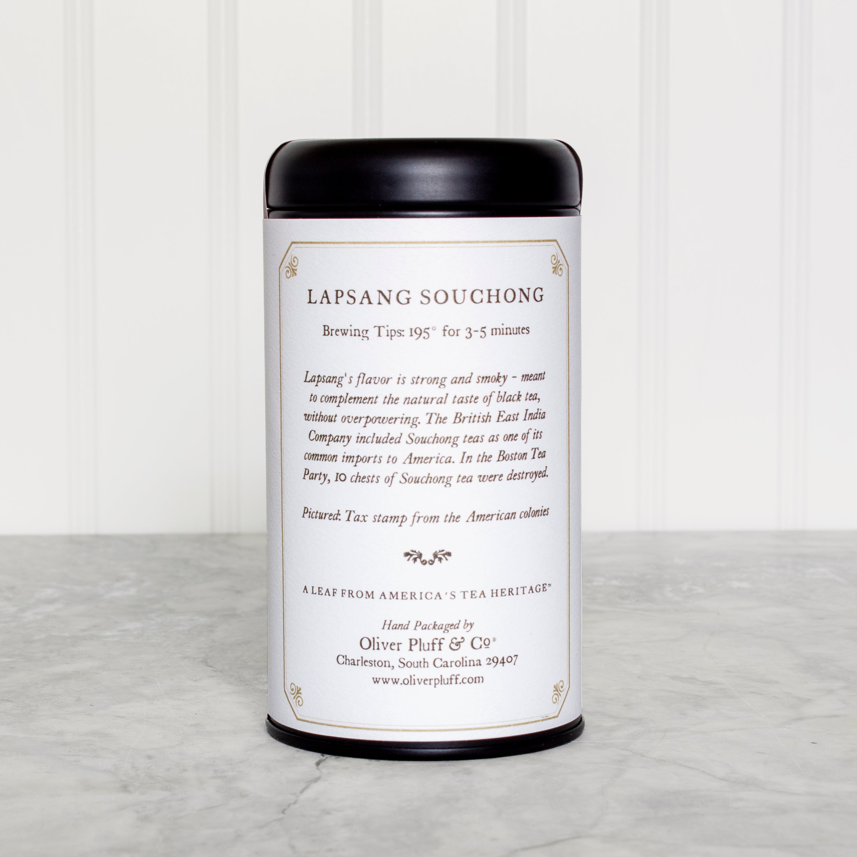 A stylish matte black tea tin containing Lapsang Souchong teabags, showcasing its elegant design and eco-friendly packaging.