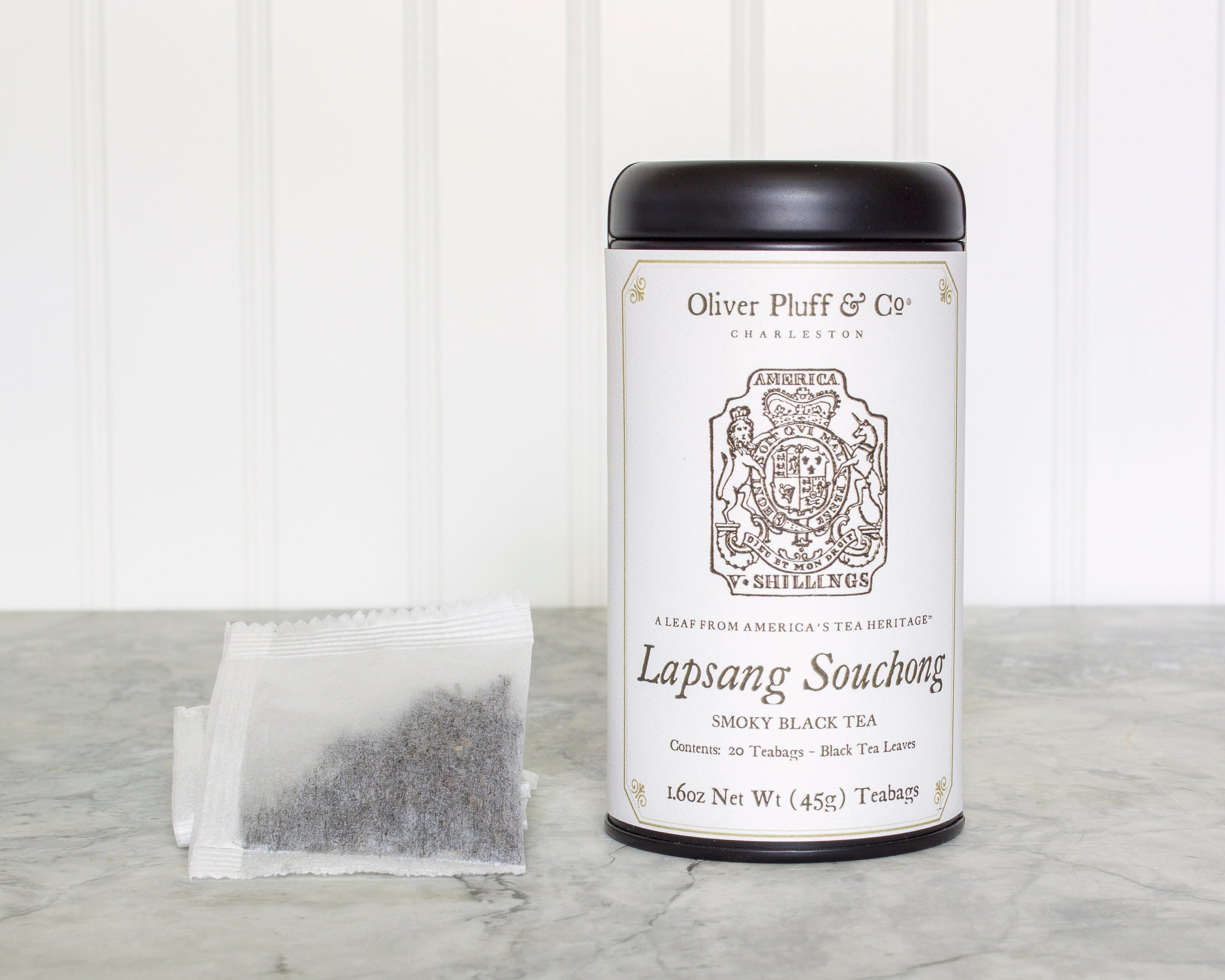 A stylish matte black tea tin containing Lapsang Souchong teabags, showcasing its elegant design and eco-friendly packaging.