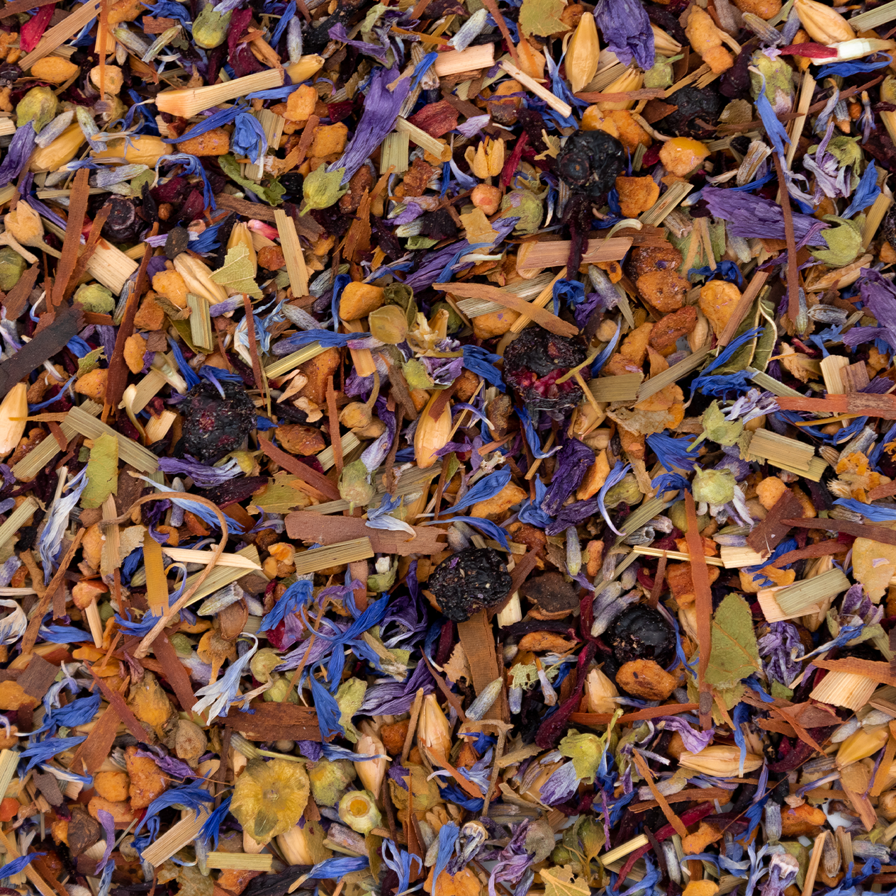 Tasse bleue remplie d'une infusion violette à la lavande et myrtille, entourée de fleurs et de fruits.