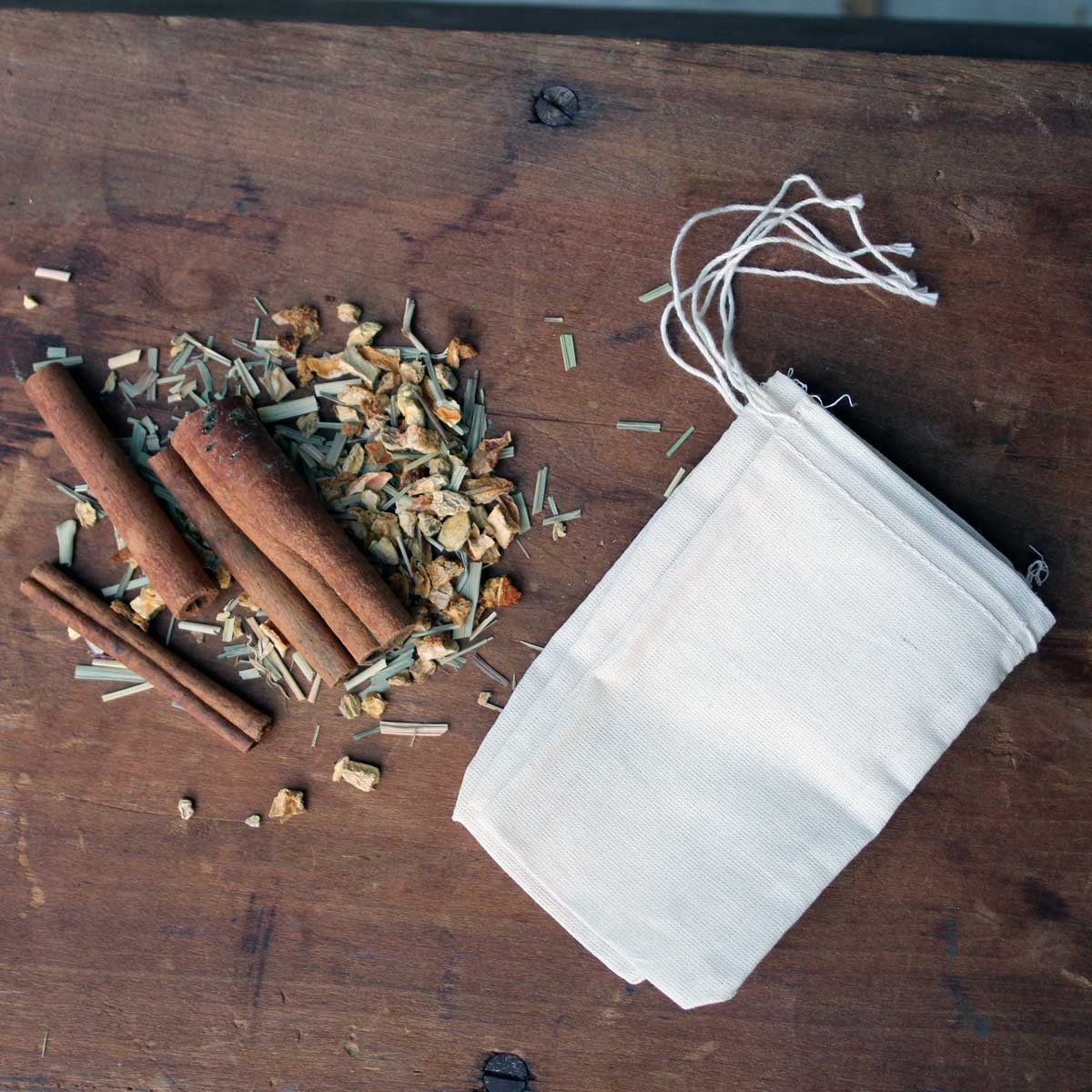 Lemon Ginger Hot Toddy Kit featuring muslin spice bags, cinnamon sticks, and dried lemon and ginger ingredients.