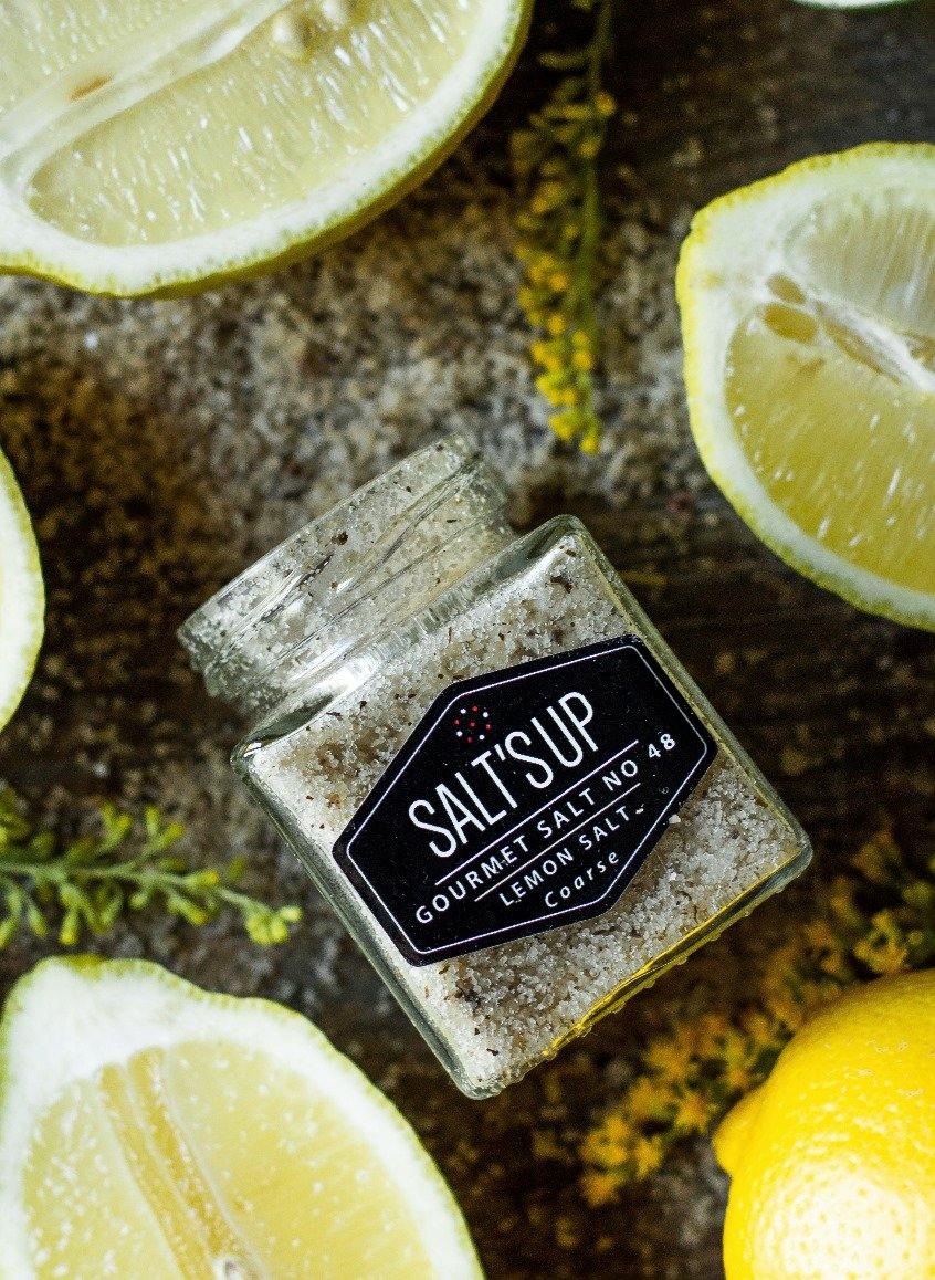 Coarse lemon salt in an eco-friendly pack, showcasing its texture and vibrant color, perfect for enhancing dishes.