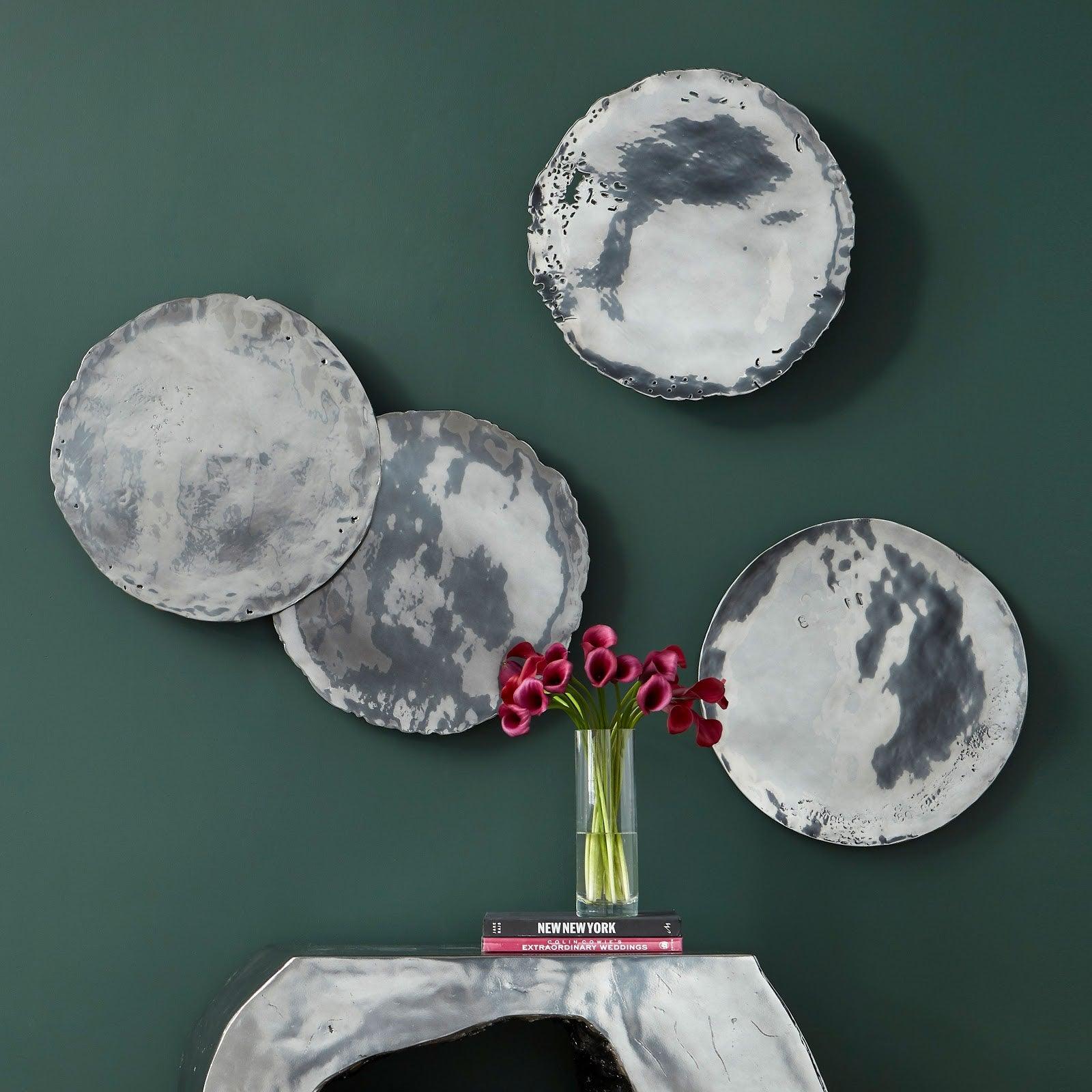 Set of four Liquid Silver Cast Oil Drum Wall Discs, showcasing a rustic design with a liquid silver finish, perfect for modern decor.