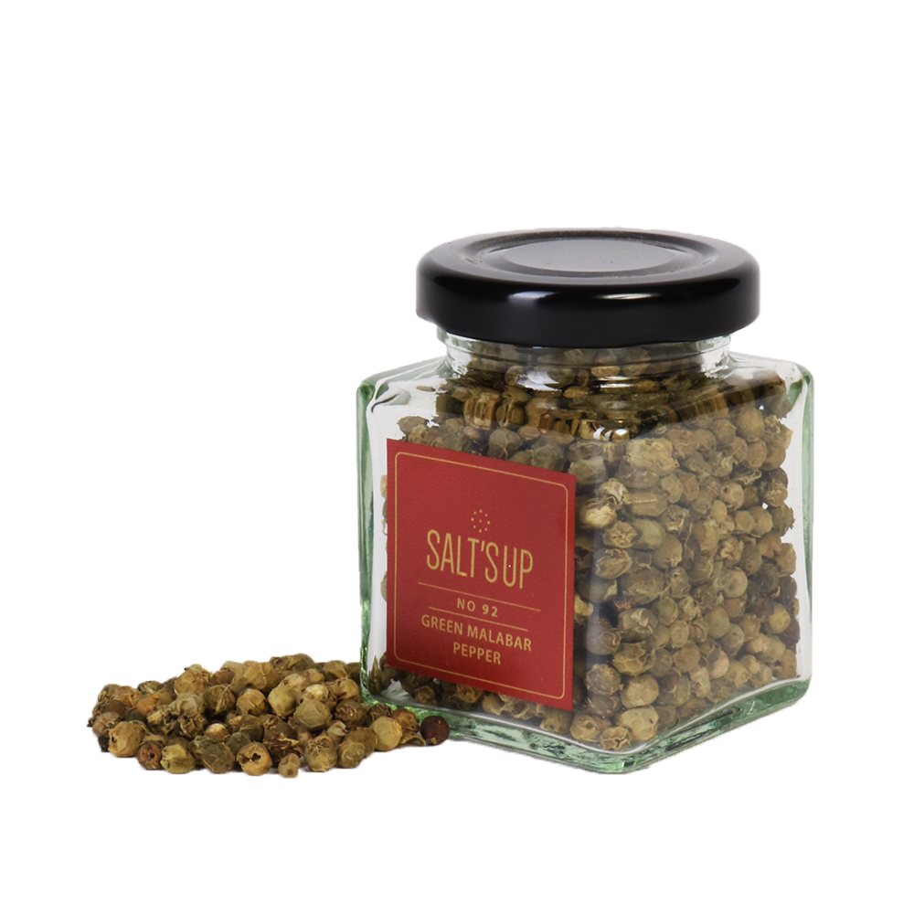 A glass jar of Malabar Green Pepper showcasing vibrant green peppercorns, sourced from Kerala, India.