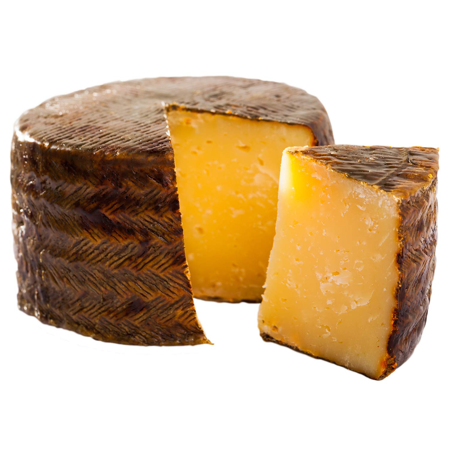 A wedge of Manchego cheese with a zigzag patterned rind, showcasing its creamy texture and straw color.